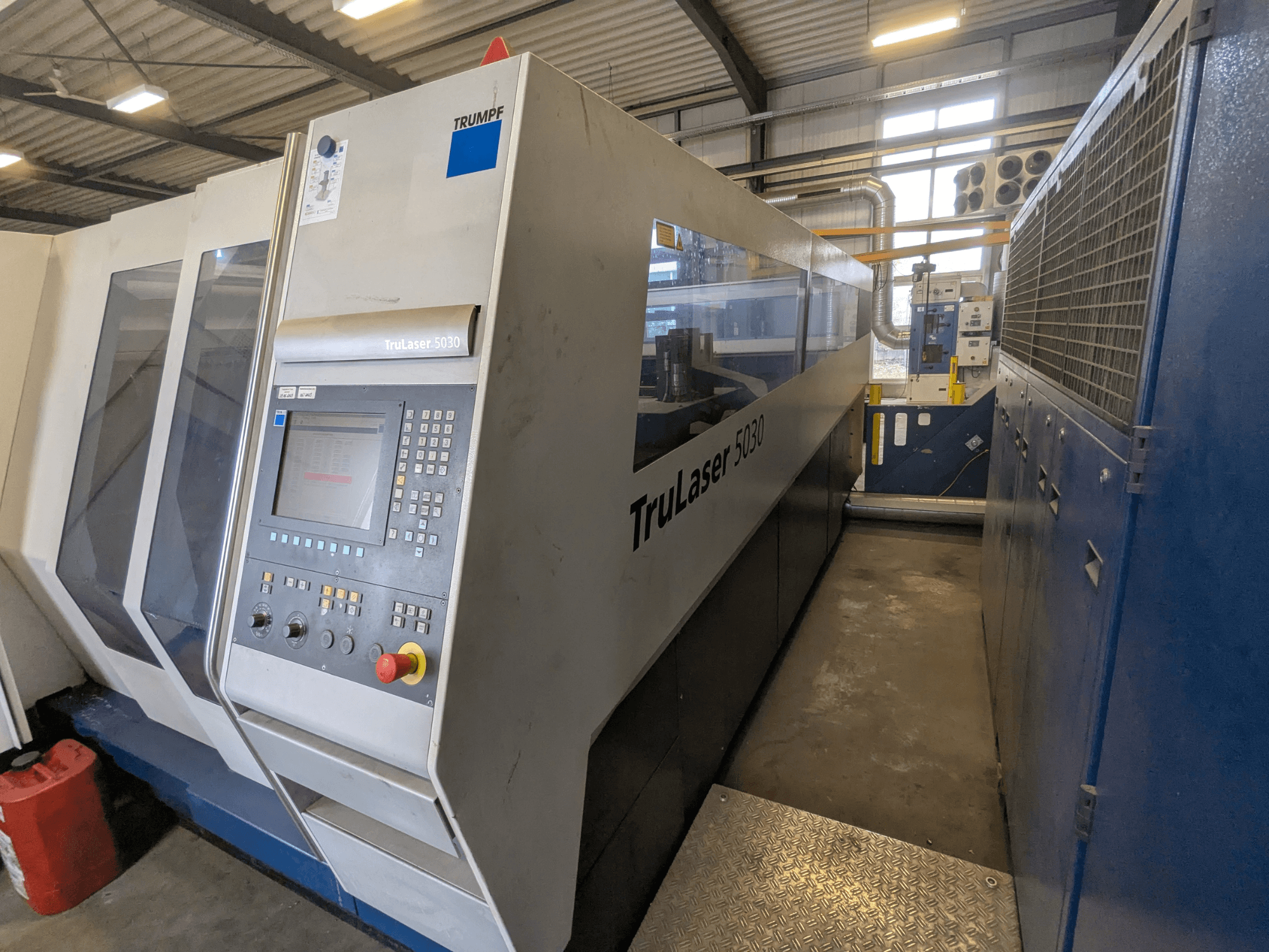 Máquina de corte a laser TRUMPF TruLaser 5030 CO2, vista frontal mostrando o painel de controlo e o design elegante, em ambiente industrial.