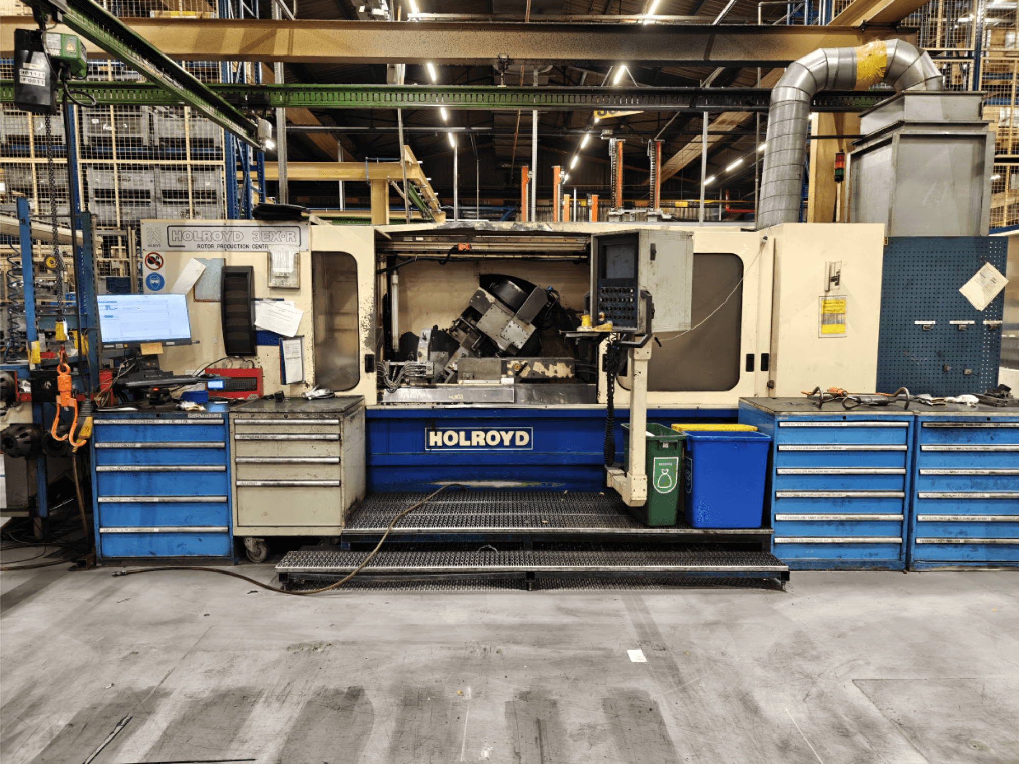 Máquina-ferramenta Holroyd 3EX-R numa oficina, vista frontal, mostrando o painel de controlo, o armazenamento de ferramentas e a área de trabalho no interior.