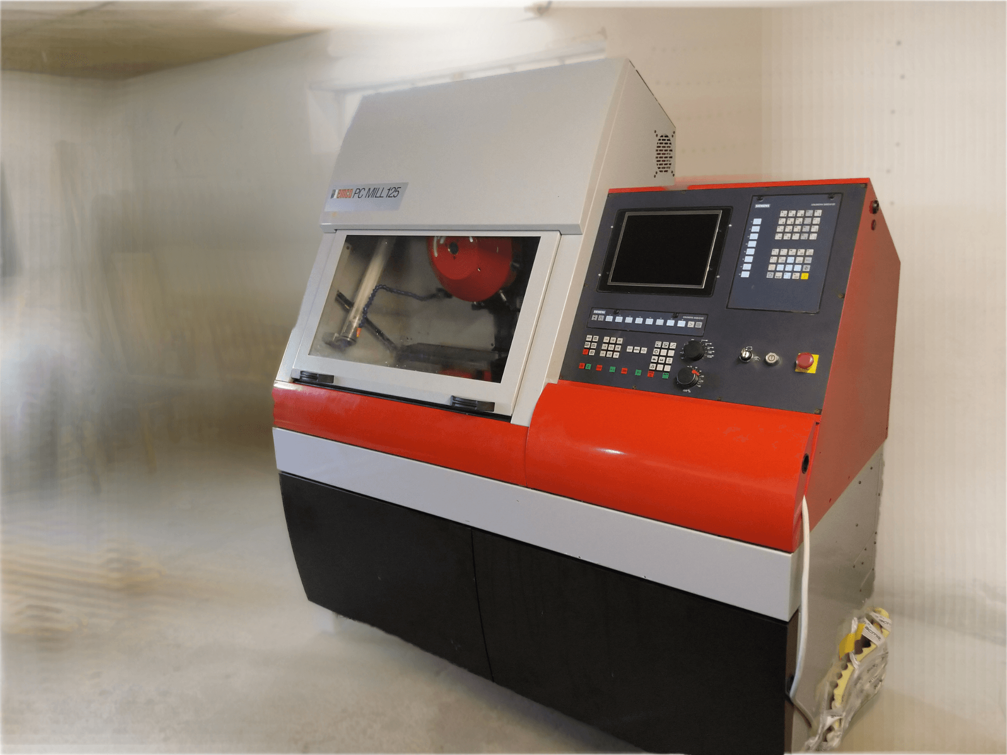 Centro de maquinação vertical EMCO PC MILL 125, vista frontal com painel de controlo e área de maquinação visível.