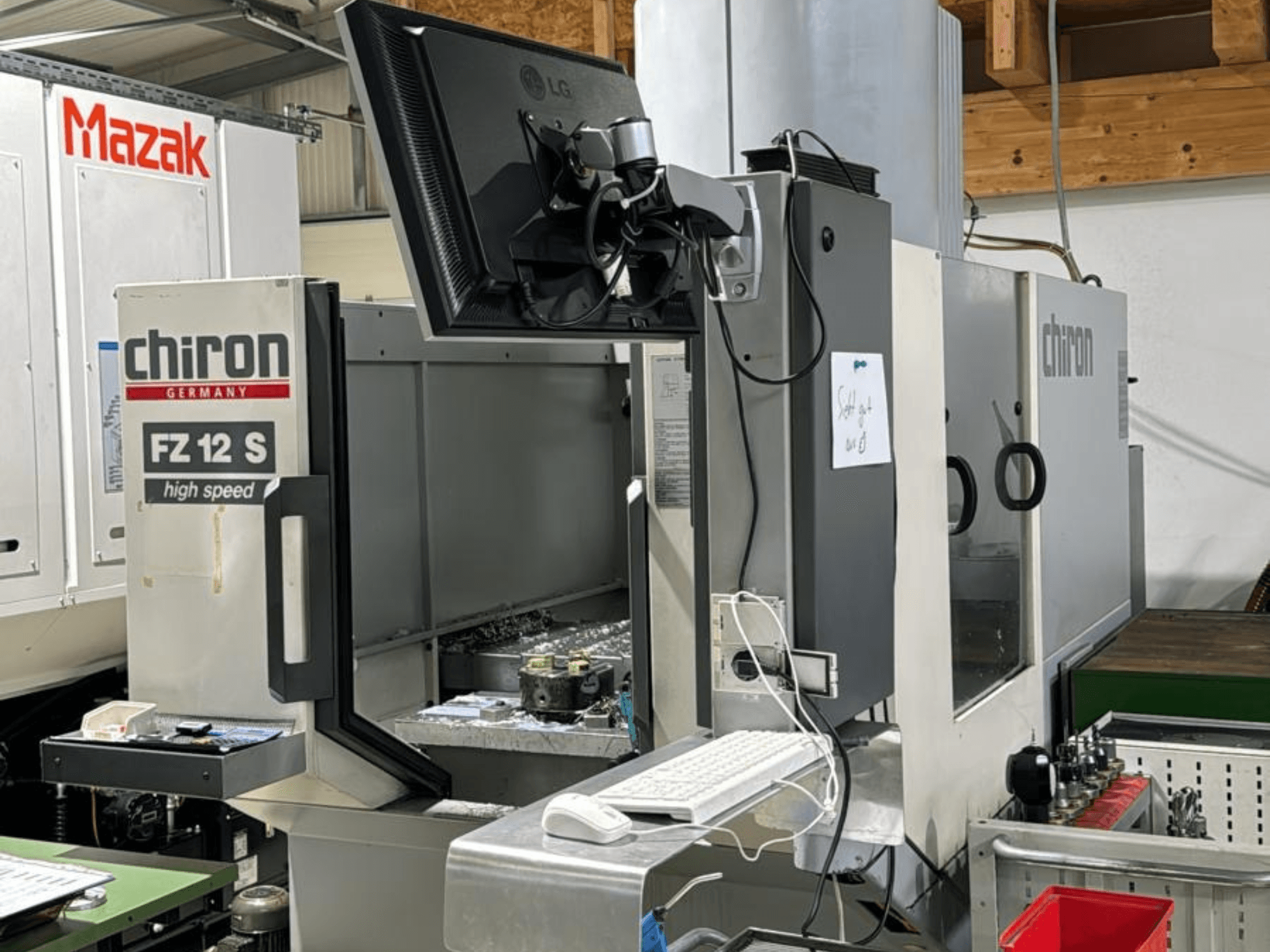 Vista vertical do centro de maquinação de alta velocidade CHIRON FZ 12 S com ecrã de controlo e detritos do processo de maquinação.