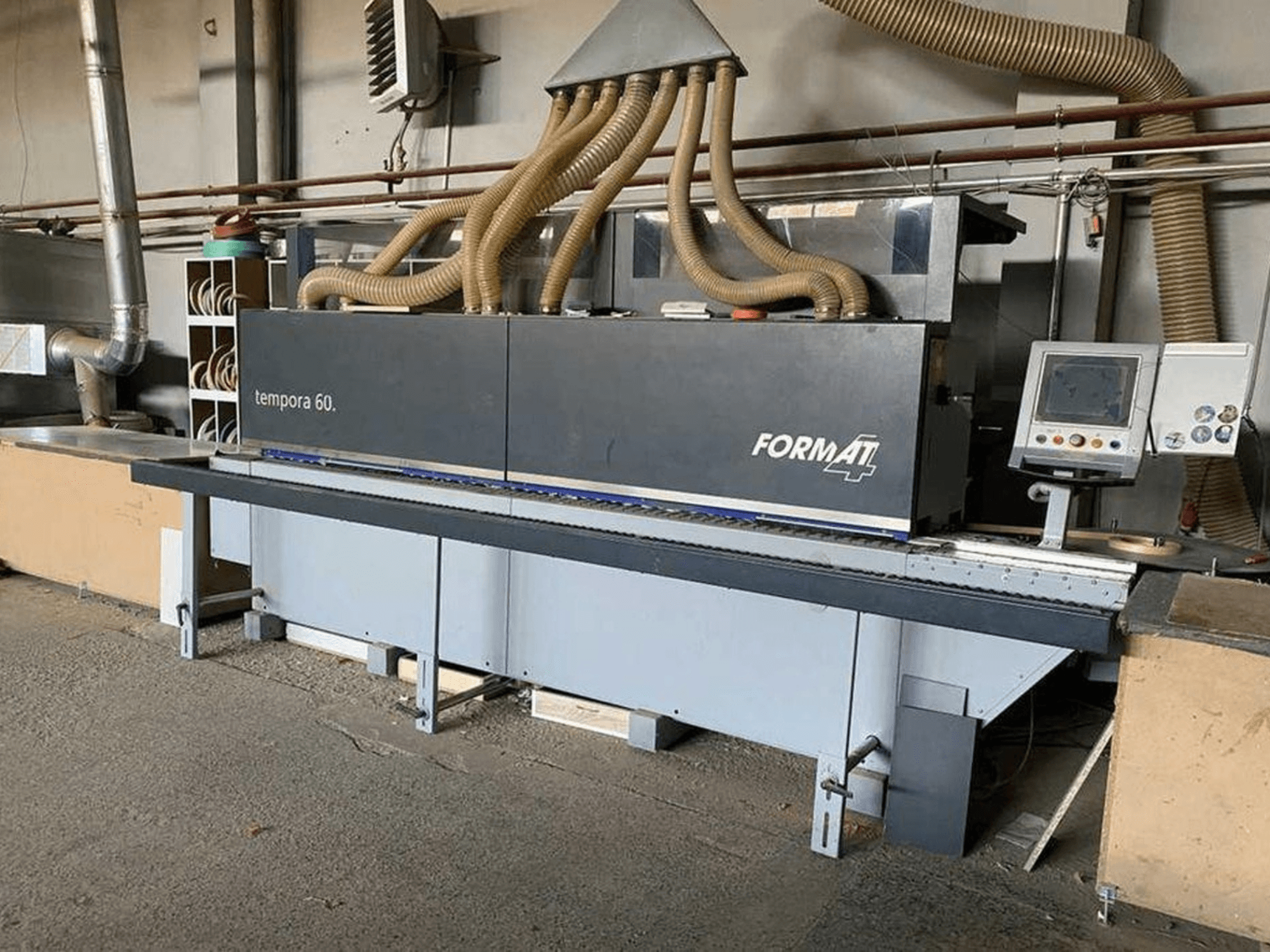 Máquina de orlas FORMAT4 Tempora 60 em vista lateral, com várias mangueiras e um painel de controlo com botões e ecrã.