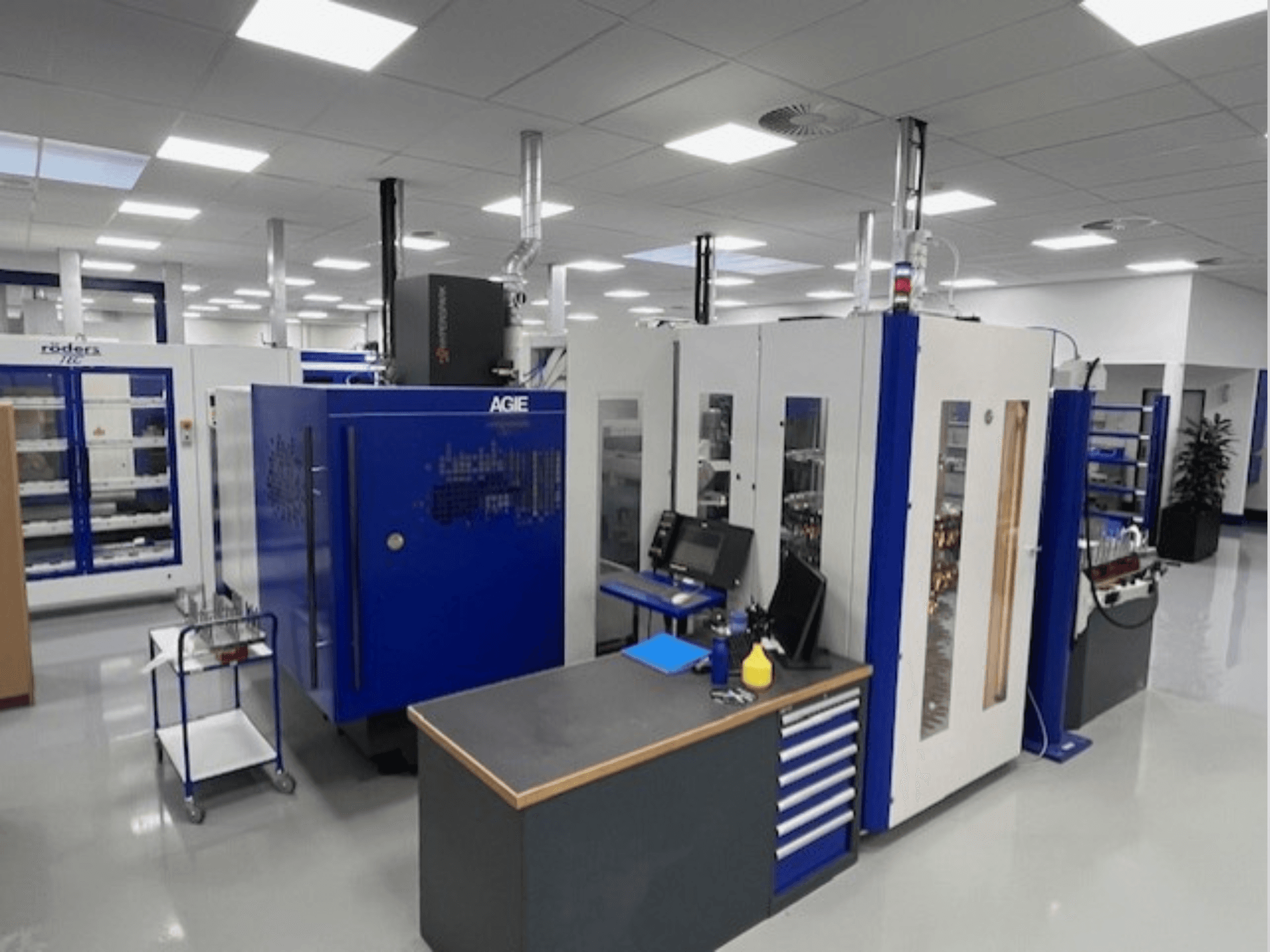 Máquina de electroerosão por penetração exacta AGIE Hyperspark 2 numa oficina, vista de frente com detalhes em azul e cinzento.