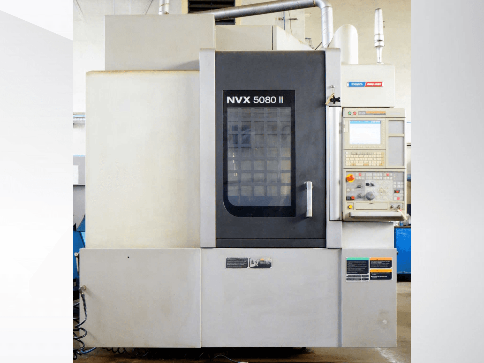 Centro de maquinagem vertical DMG Mori Seiki NVX 5080 II, vista frontal, com destaque para o painel de controlo e o design da porta em grelha.