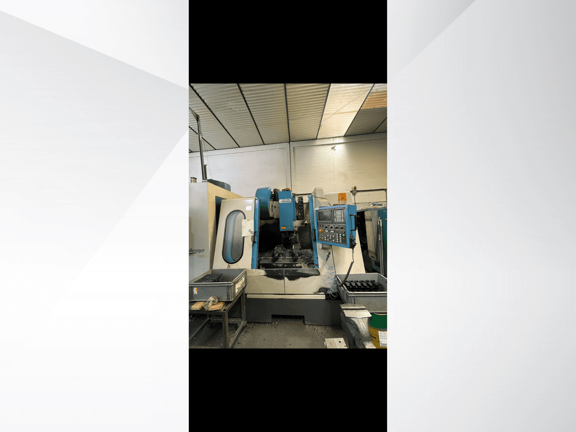 Máquina CNC, modelo Challenger 1500, vista lateral mostrando o painel de controlo e o espaço de trabalho com aparas de metal.