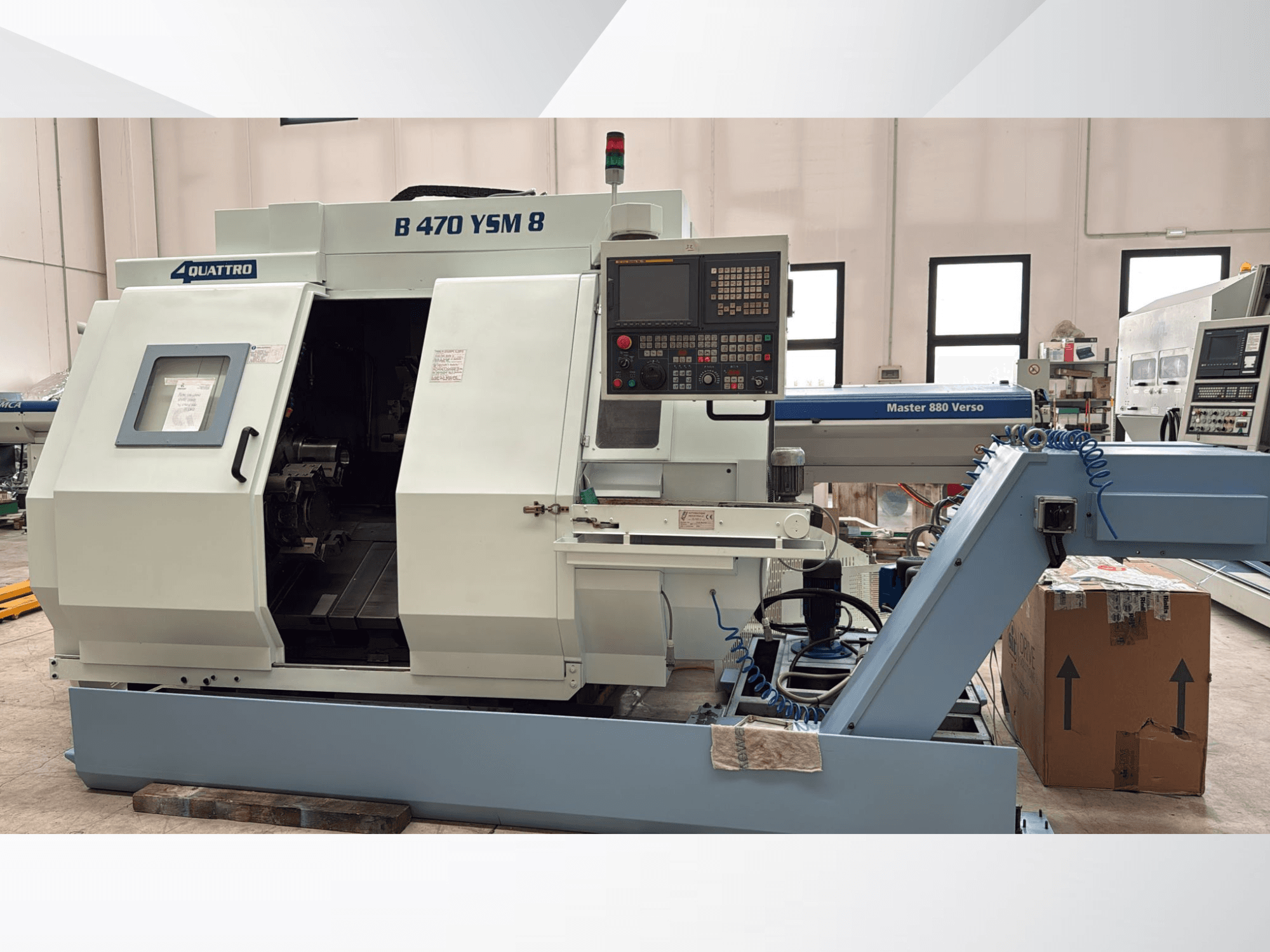 Biglia B470 YSM, centro da fresadora, vista frontal mostrando o painel de controlo, a escotilha aberta e o espaço de trabalho com ferramentas no interior.