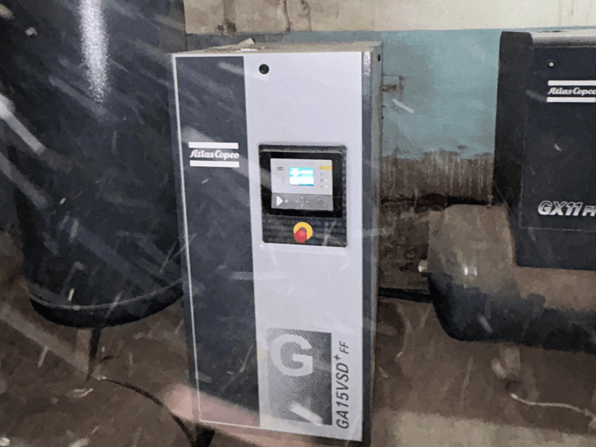 Compressor de ar Atlas Copco GA15VSD+FF, vista frontal, inclui painel de controlo com ecrã e botão vermelho de paragem de emergência.