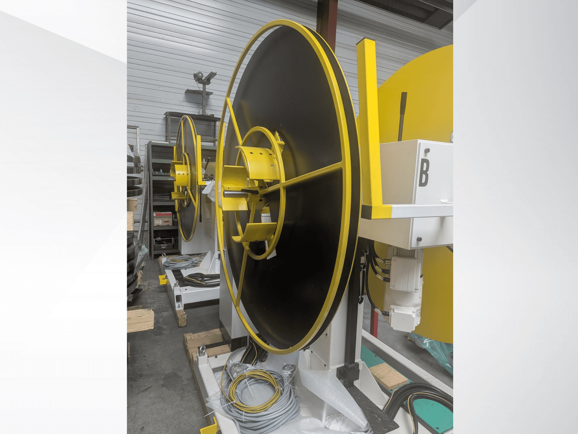 Bobina industrial de grandes dimensões, modelo XYZ, com uma superfície preta e detalhes amarelos, vista de lado, com ligações eléctricas.