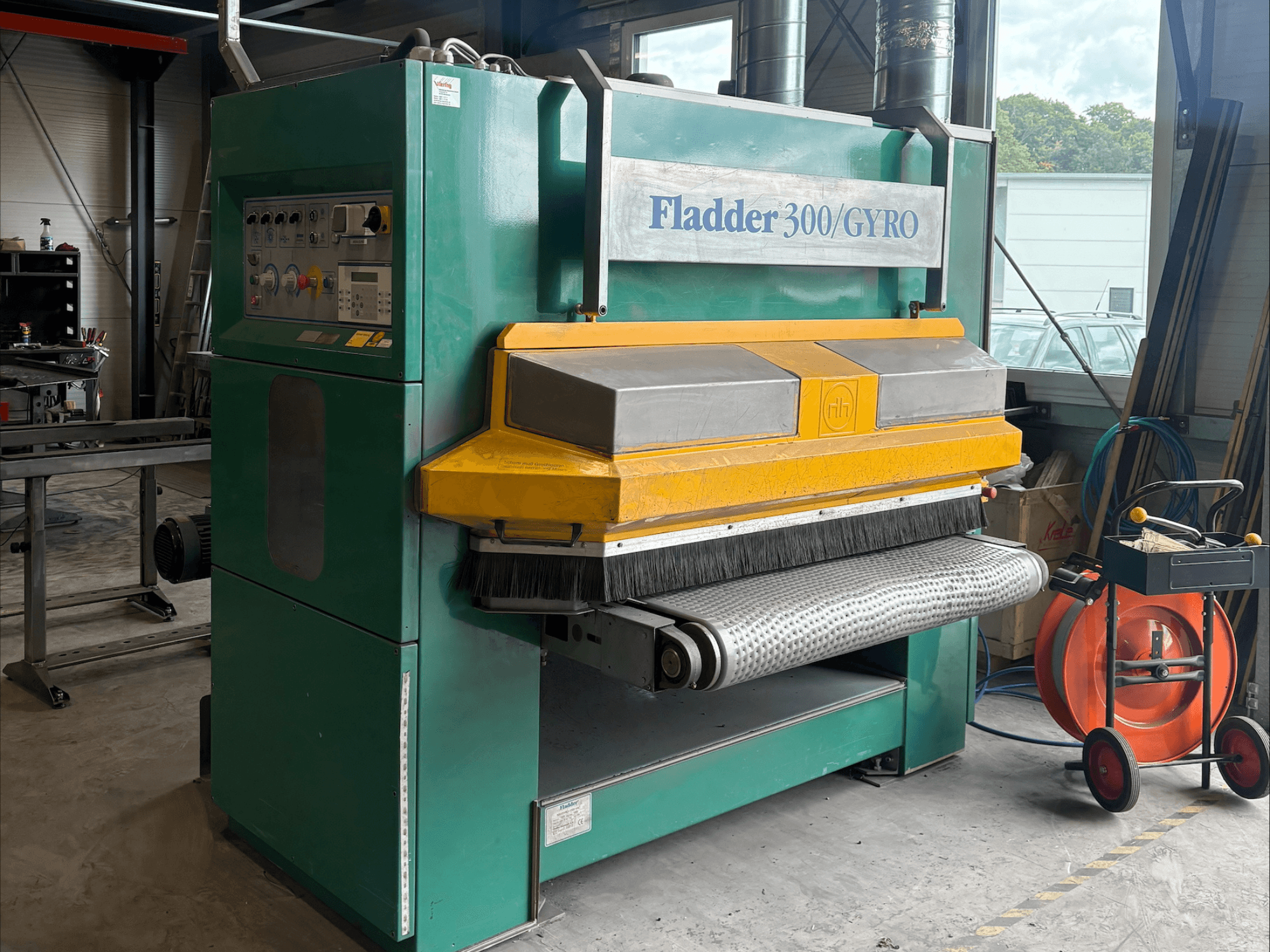 Lixadeira industrial Fladder 300/GYRO em verde e amarelo, vista frontal, com painel de controlo e tambor de lixagem.