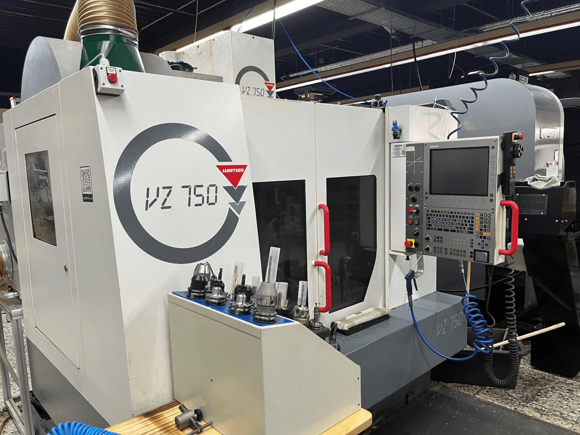 Centro de maquinação vertical WEMAS VZ 750, vista frontal, mostra o painel de controlo, suportes de ferramentas e detalhes de design da máquina.