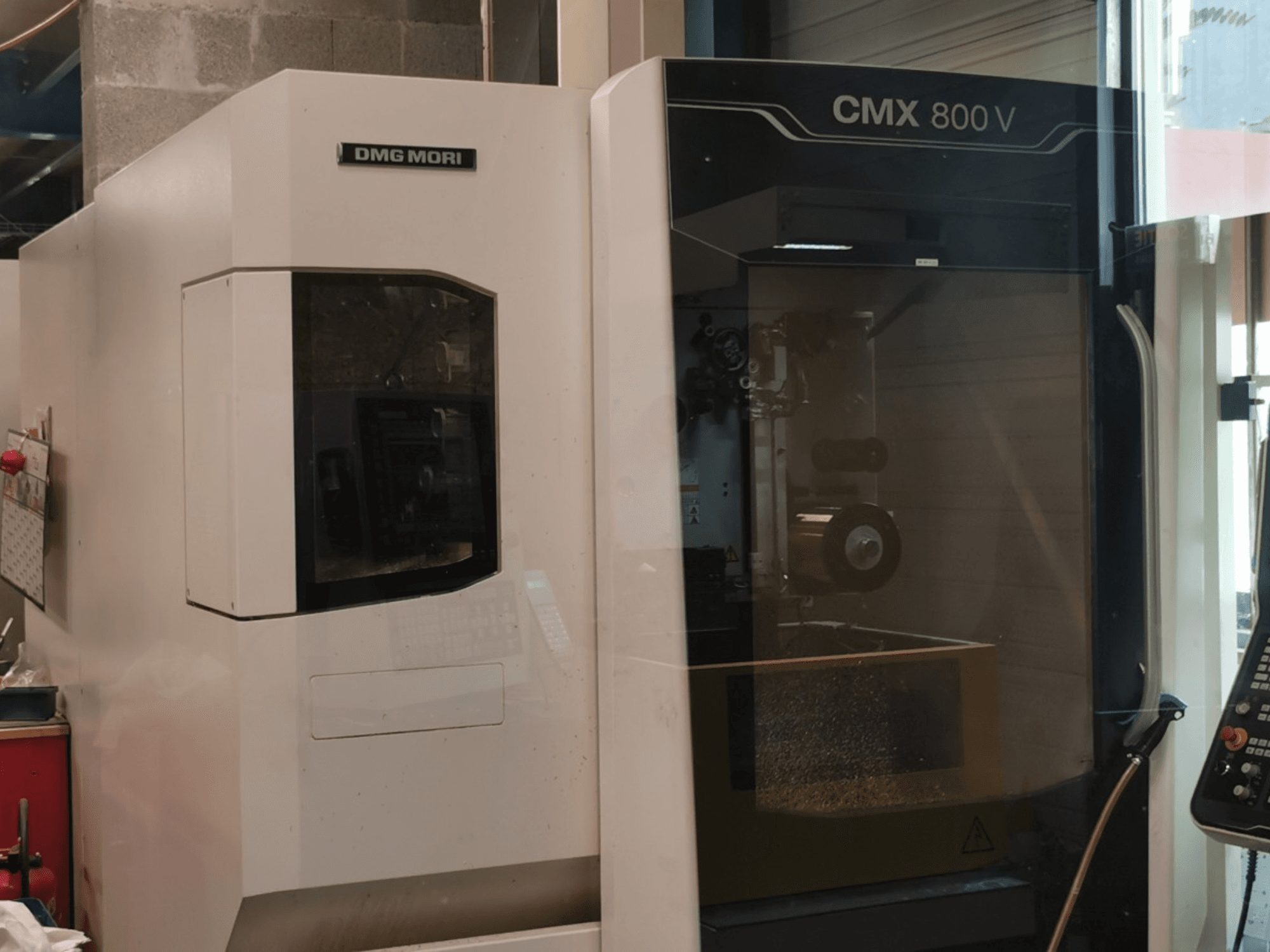 Centro de maquinagem vertical DMG Mori Seiki CMX 800 V, vista frontal que mostra o painel de controlo e a área de trabalho com as ferramentas visíveis.