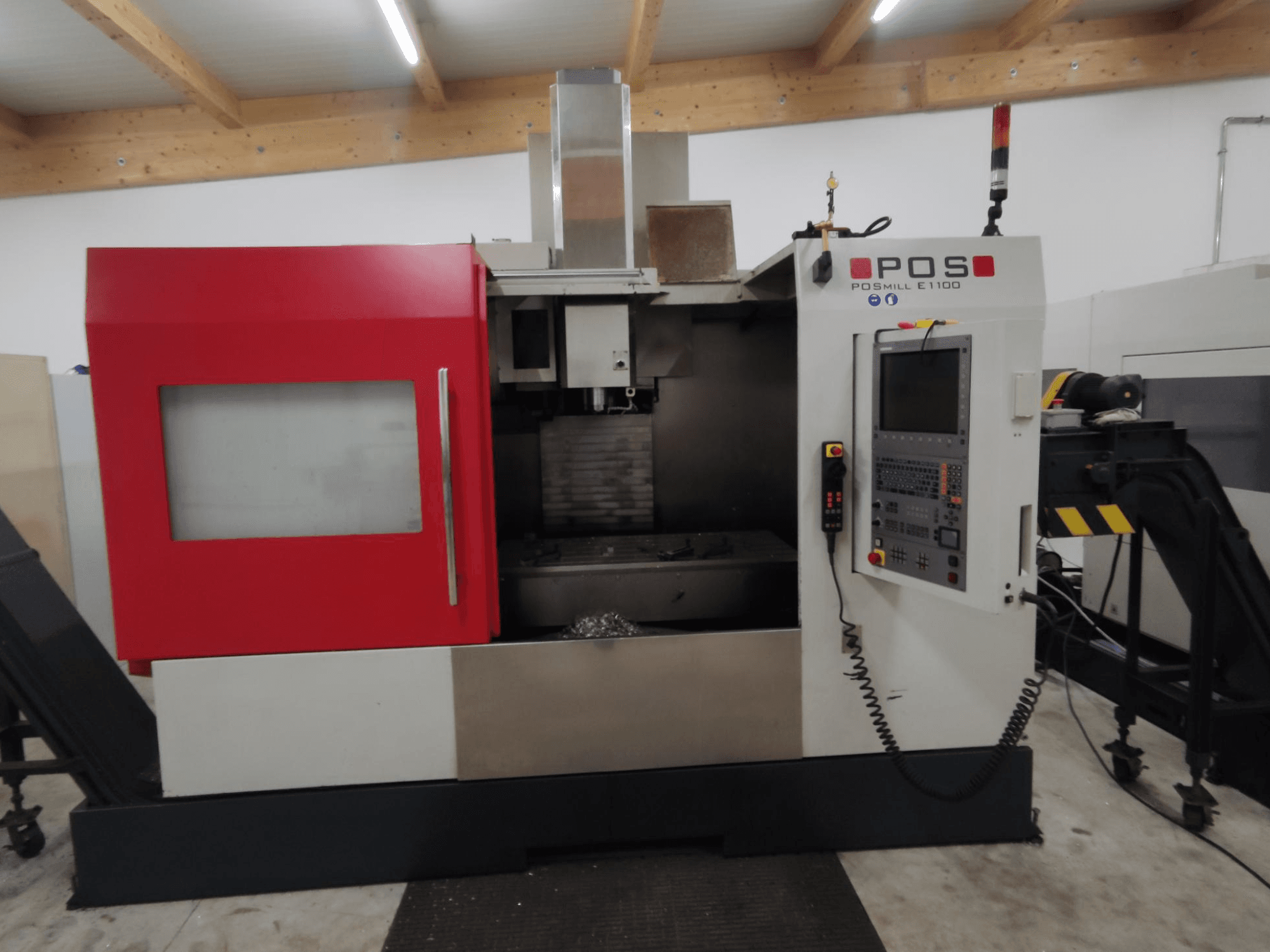 Fresadora CNC POS PSMILL E1100, vista frontal, com caixa vermelha e prateada, painel de controlo e luzes indicadoras de segurança.