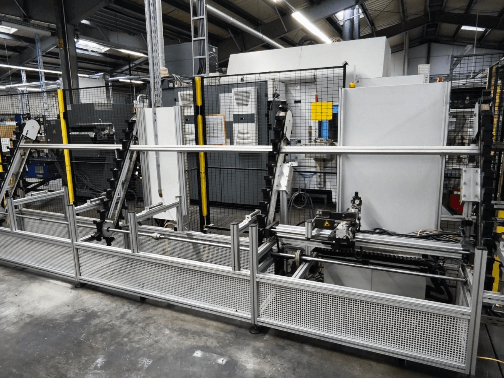 Sistema de manuseamento de peças LOHMEIER Schräglademagazin em vista frontal, mostrando a sua estrutura metálica e componentes mecânicos integrados.