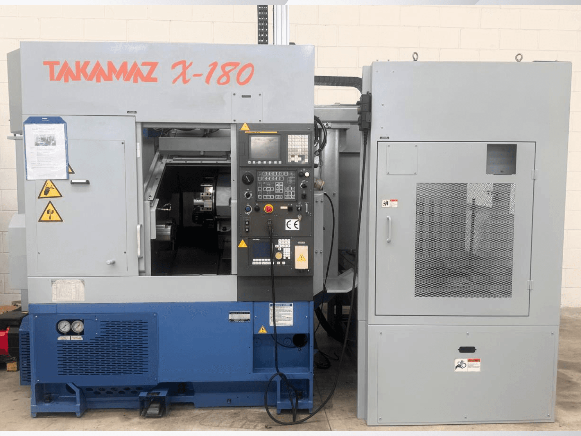Torno horizontal Takamaz X-180, vista frontal que mostra o painel de controlo, as etiquetas de segurança e a unidade de arrefecimento adjacente.