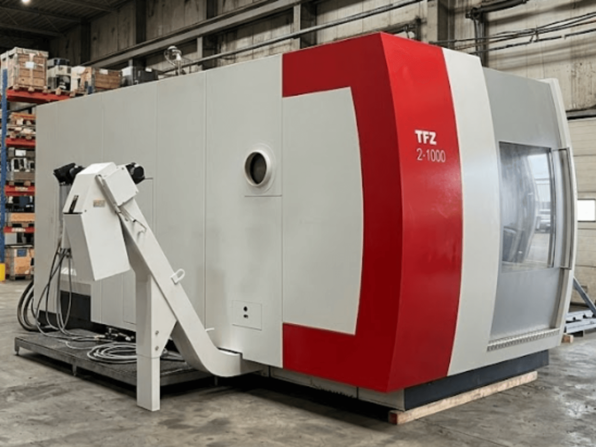 Centro de maquinagem universal SAMAG TFZ 2L-1000, vista lateral que mostra o seu design em vermelho e cinzento e o braço robótico acoplado.