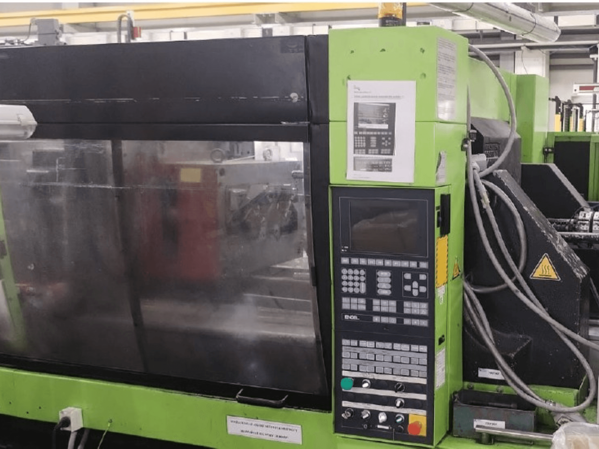 Máquina de moldagem por injeção hidráulica Engel ES 1050/275 HL-V, vista lateral que mostra o painel de controlo e detalhes operacionais.