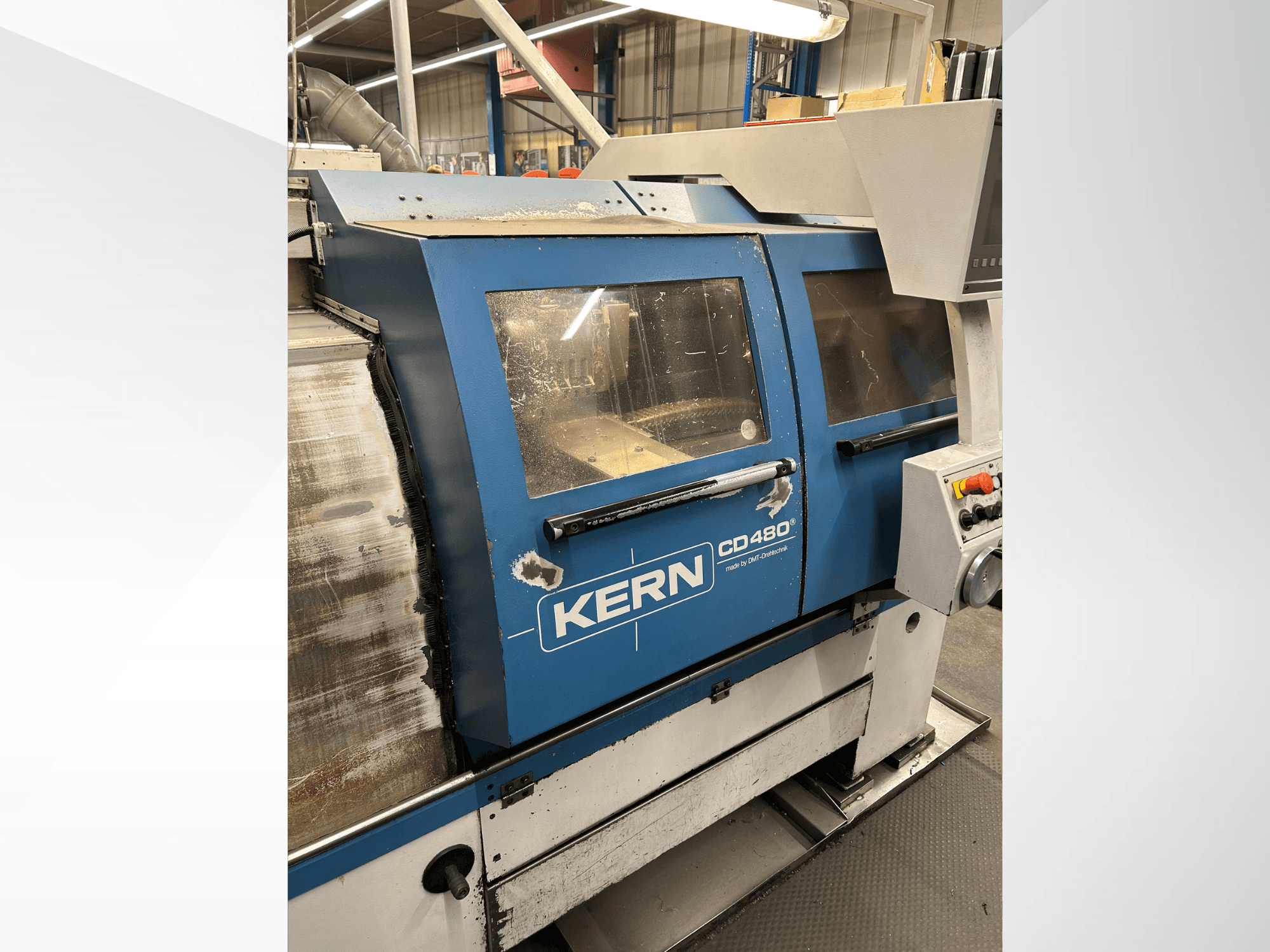 Torno horizontal DMT Kern CD480, vista lateral que mostra o painel de controlo, as grandes janelas e a estrutura metálica.