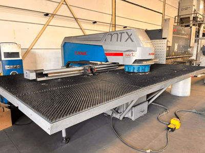 Máquina de perfuração CNC Euromac MTX FLEX 12, vista frontal, com uma grande mesa perfurada e um painel de controlo.