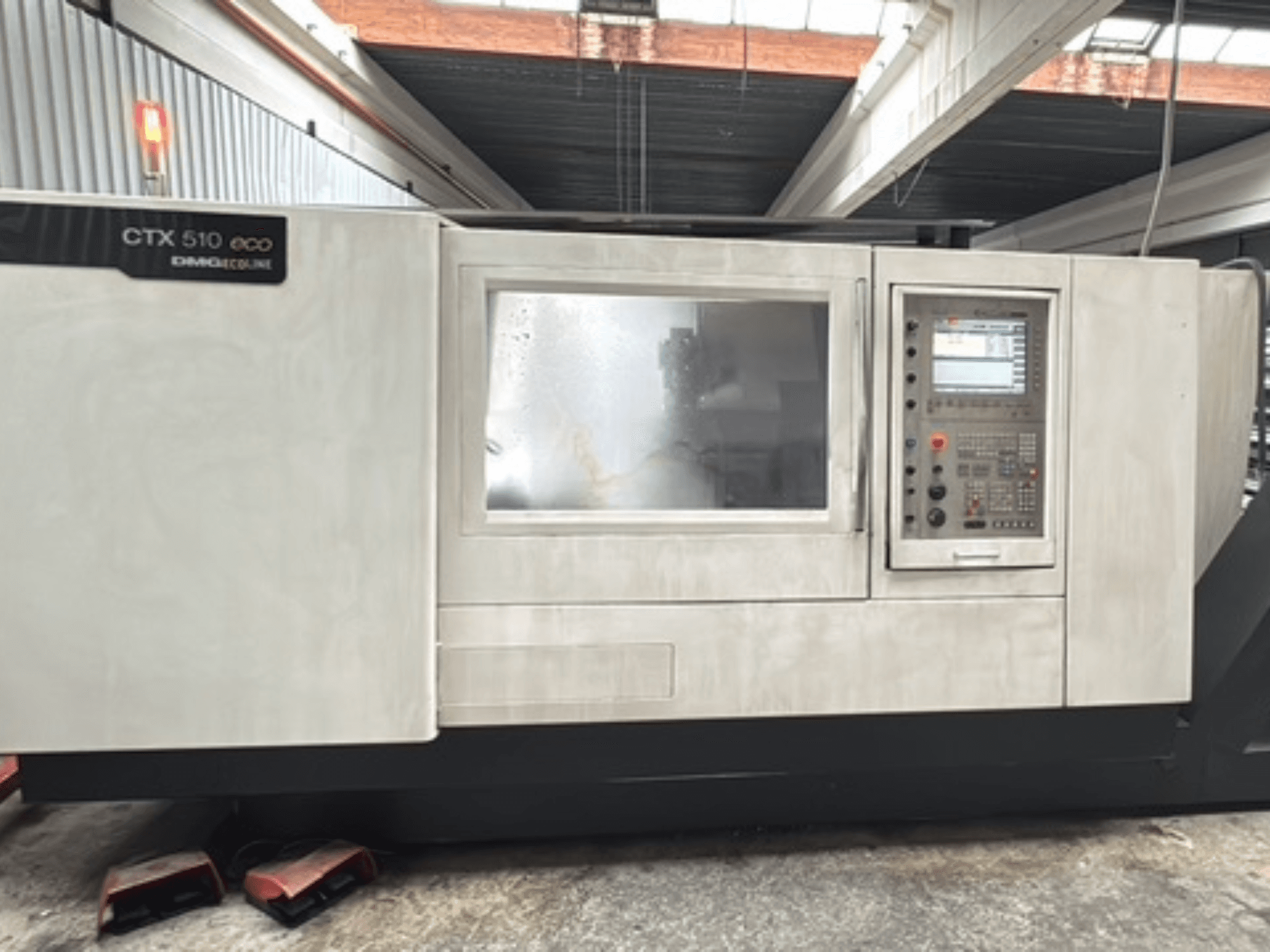 Torno horizontal DMG CTX 510 ecoline, vista frontal, mostrando o painel de controlo e a janela no corpo da máquina.