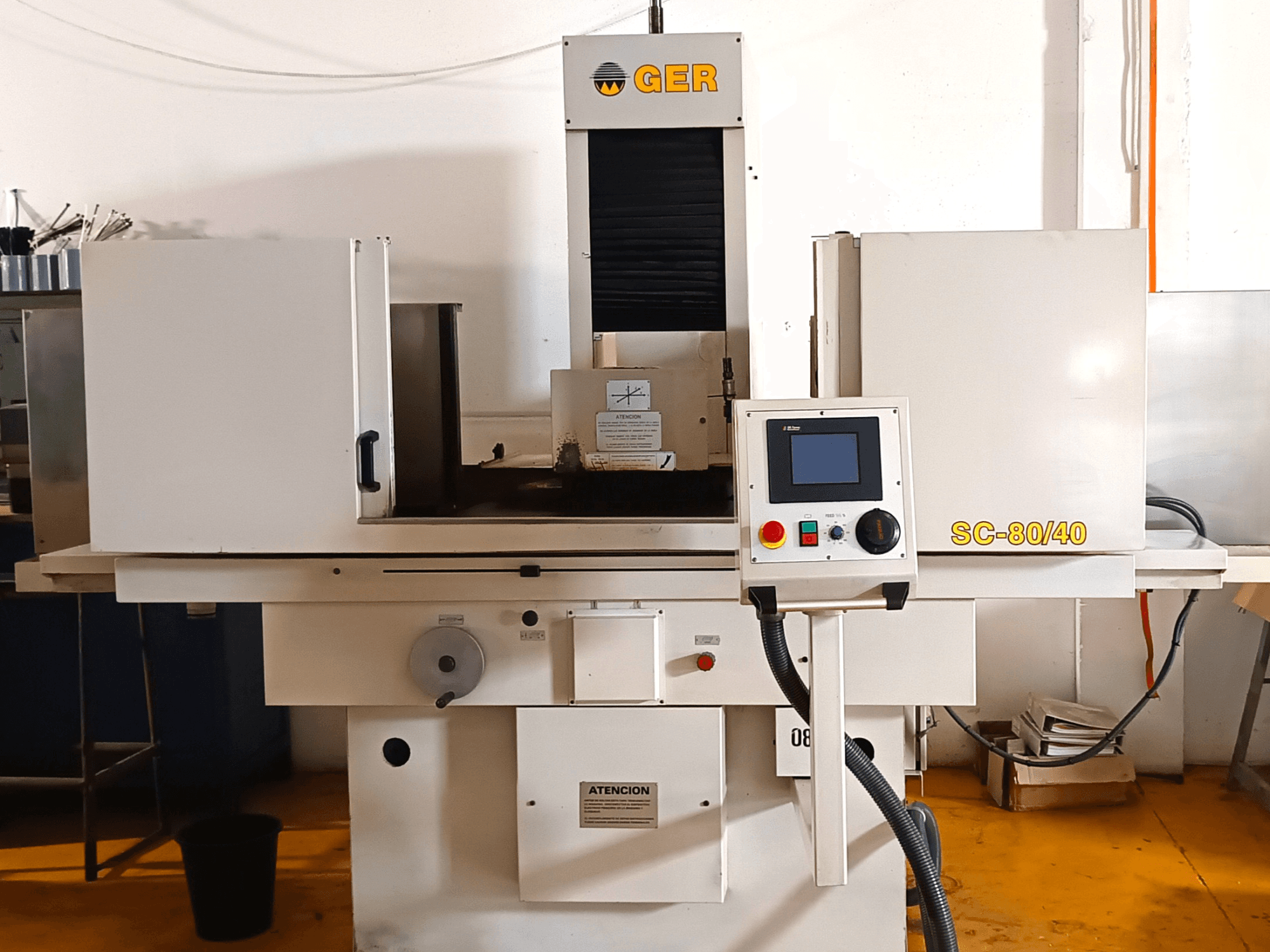 Máquina de retificação plana GER SC 80-40, vista frontal, apresentando o painel de controlo, a área de retificação e as etiquetas de segurança.
