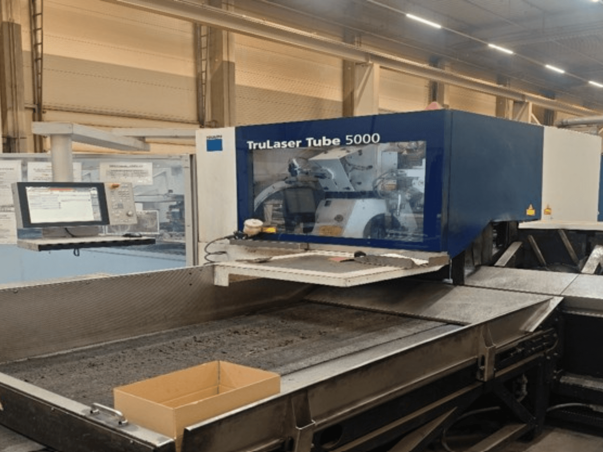 TRUMPF TruLaser Tube 5000 numa vista frontal, mostrando o painel de controlo e a área de corte para operações precisas de corte de tubos.