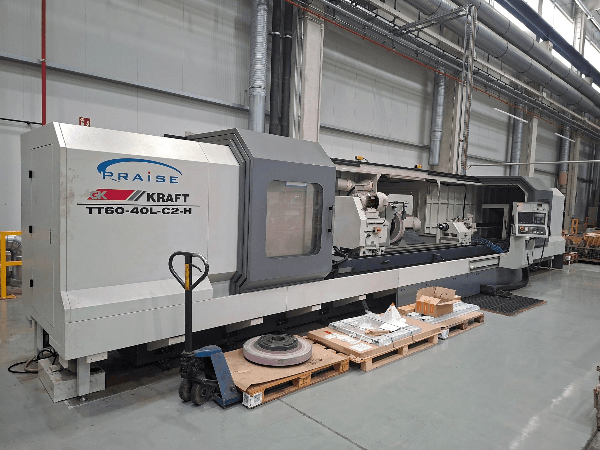 Máquina de retificação cilíndrica KRAFT TT60-40L-C2-H, vista lateral, mostrando os comandos e o rebolo num ambiente de oficina.