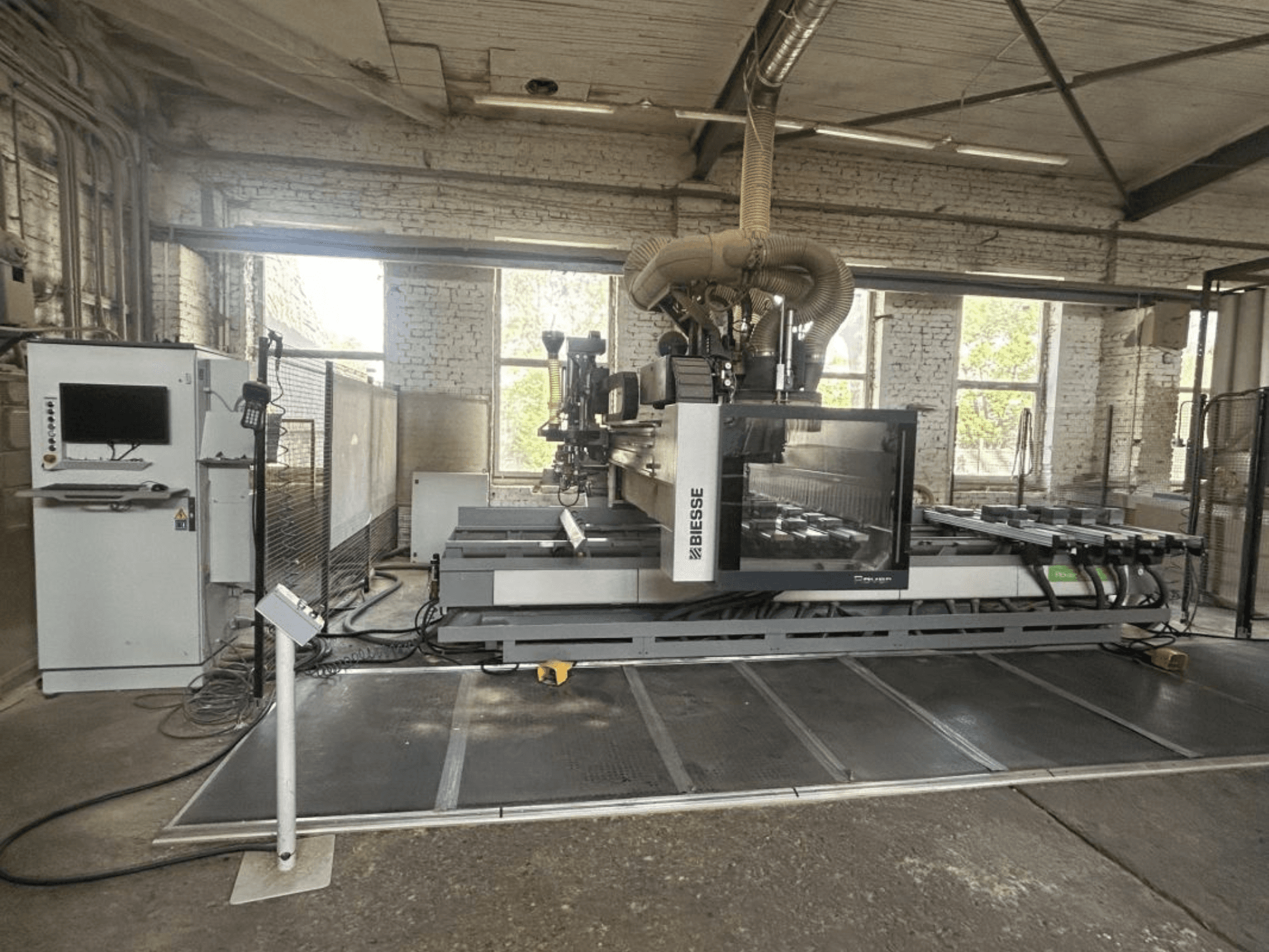 Centro de processamento CNC BIESSE Rover A Edge 1643, vista frontal, mostrando o painel de controlo, a mesa de trabalho e o ambiente industrial.