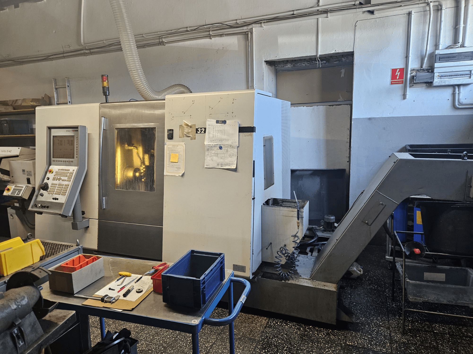 Torneiro multifuso DMG GILDEMEISTER Sprint 32 linear, vista frontal numa oficina, com painel de controlo e ferramentas visíveis.