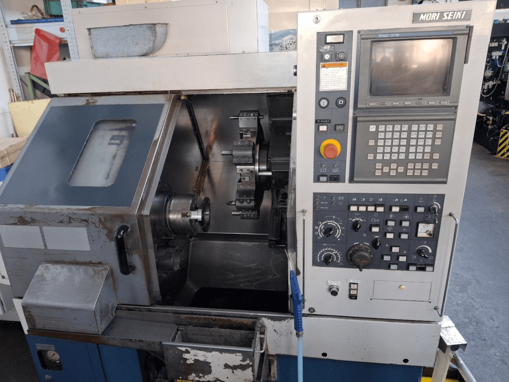 Torneiro horizontal MORI SEIKI CL 15, vista frontal mostrando o painel de controlo e a área de maquinação.