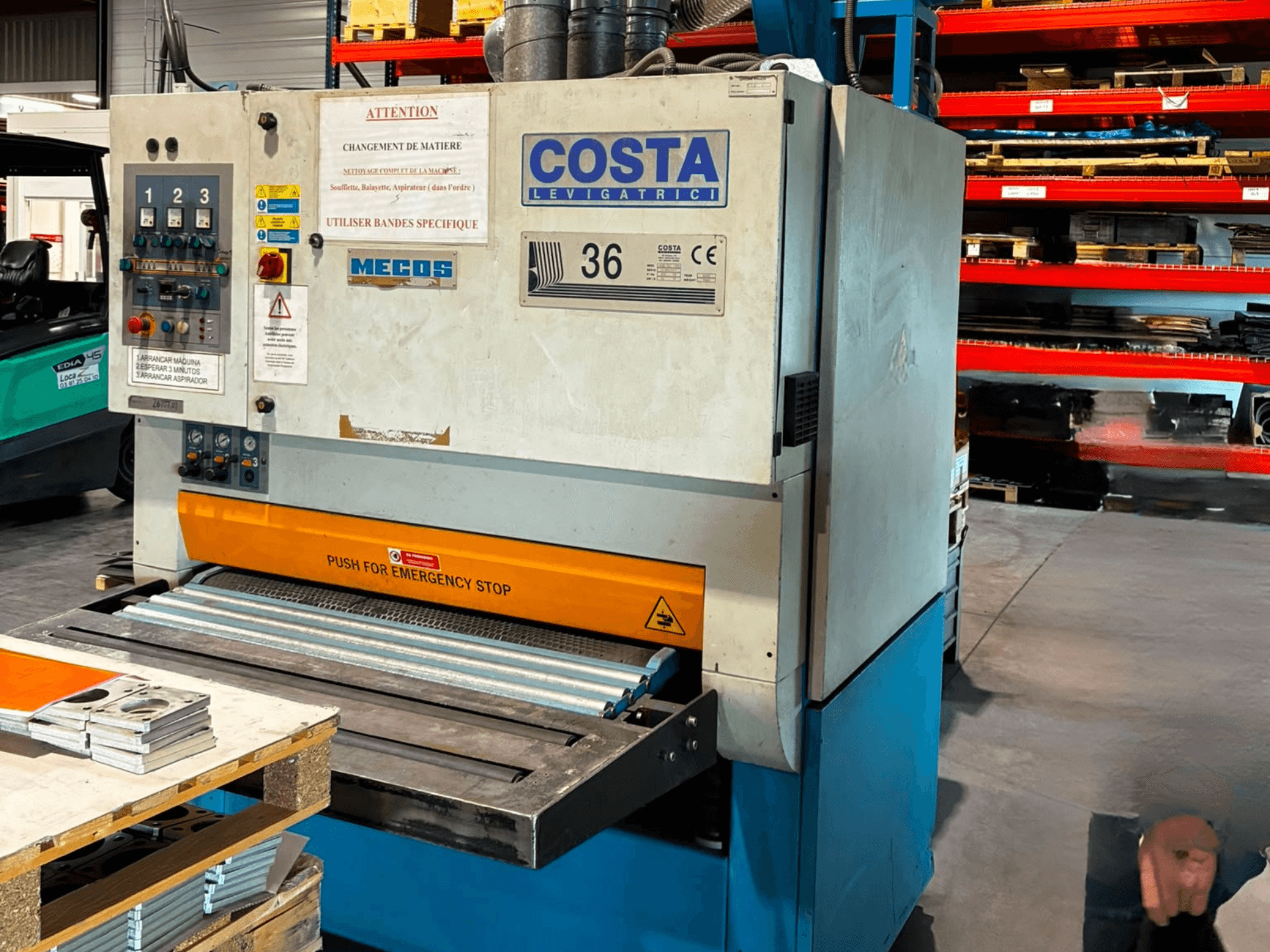 Máquina de rebarbação Costa M36 CCS 1150 vista de lado, com painel de controlo, paragem de emergência e superfície transportadora.