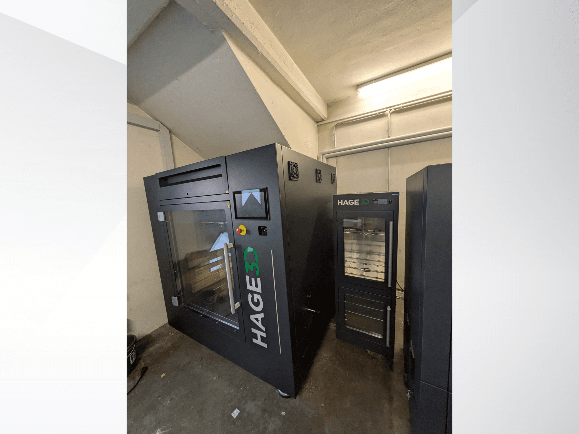 Impressora 3D de plástico HAGE 3D Precision One, vista de canto, com porta e painel de controlo transparentes e espaço de arrumação ao lado.