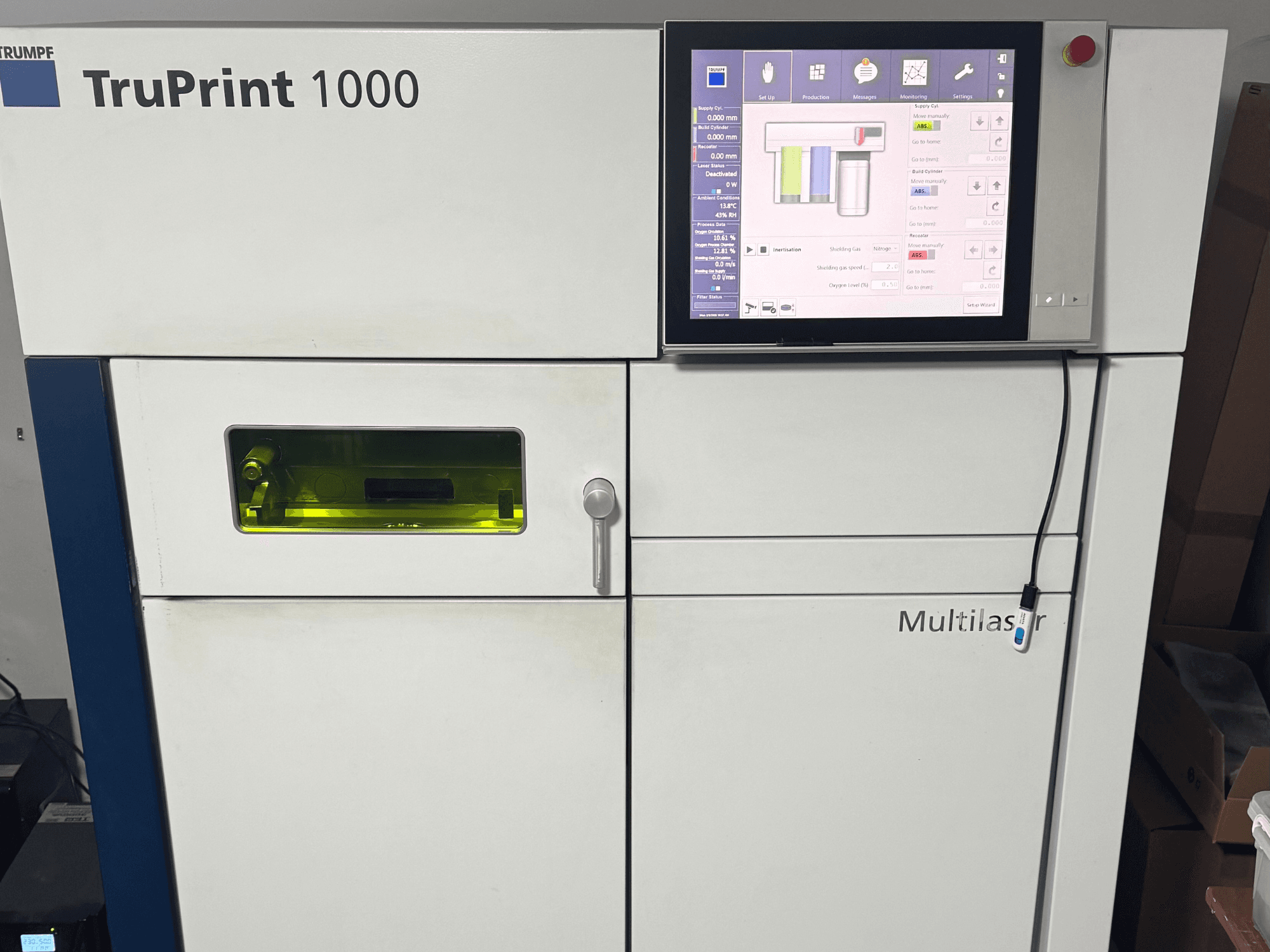 TruPrint 1000 da Trumpf, vista frontal, com um painel de controlo digital e uma janela de inspeção transparente para monitorização.