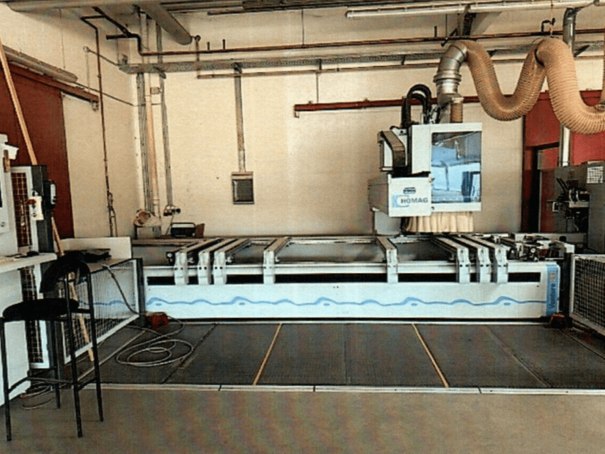 Centro de maquinação CNC para madeira HOMAG BAZ 211/40K numa oficina, mostrando o painel de controlo da máquina e a área de corte.