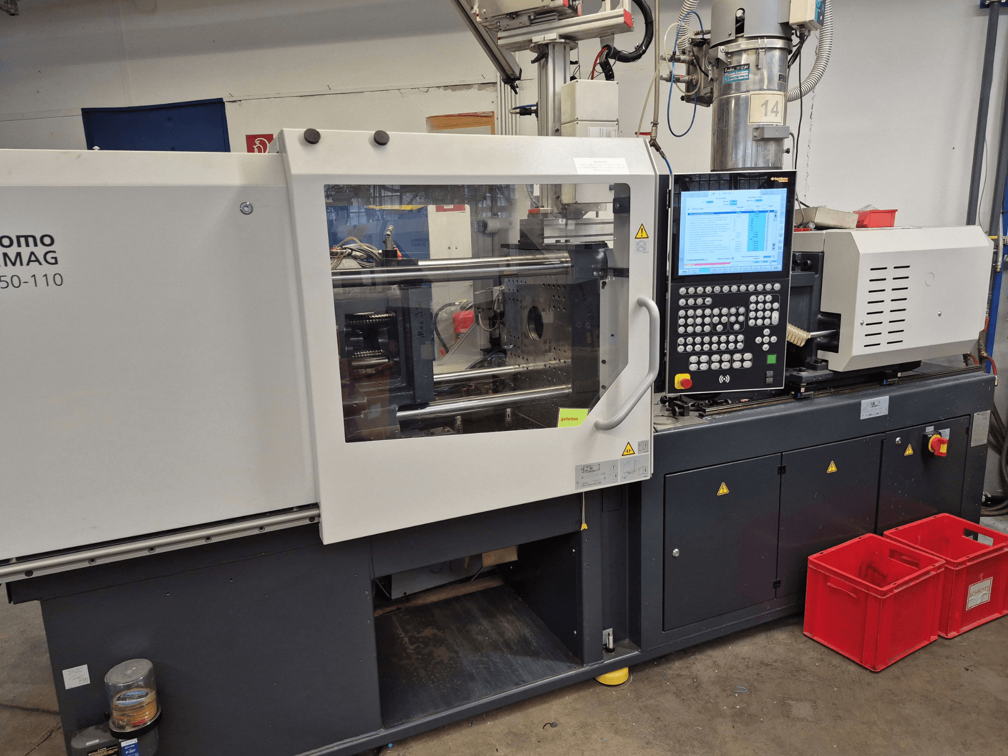 Máquina de moldagem por injeção elétrica SUMITOMO SHI DEMAG Intelect 2 50/360-110, vista lateral com o painel de controlo e os dispositivos de segurança visíveis.