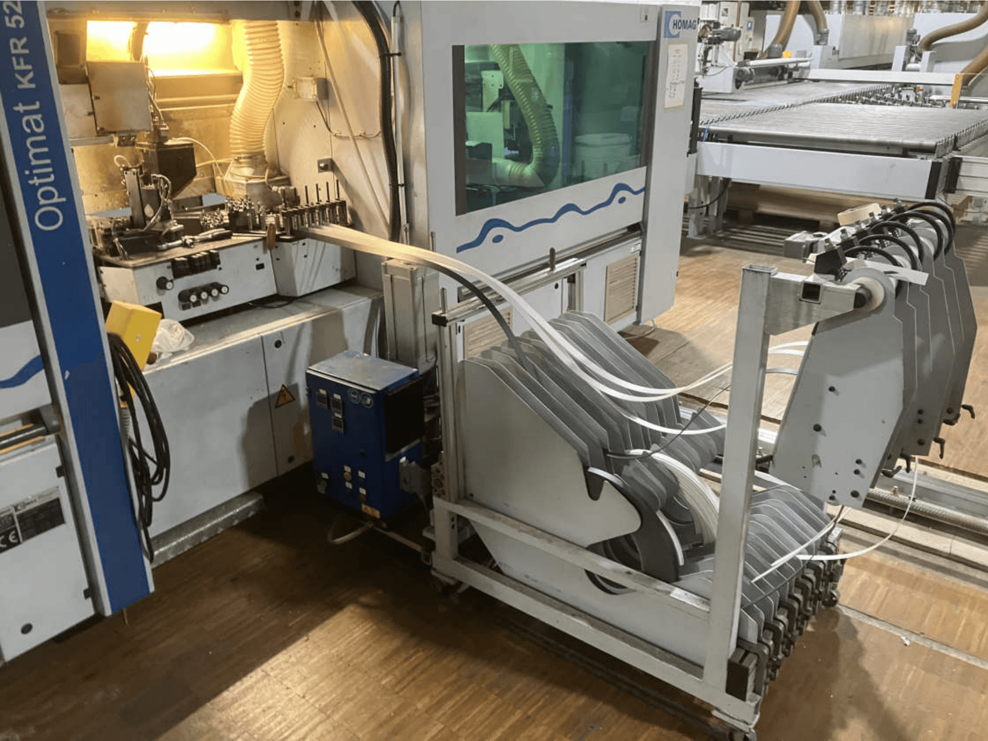 Máquina de colagem de bordas de dupla face HOMAG Optimat KFR 526/10/A3/35, vista de lado, mostrando o painel de controlo e os rolos de colagem de bordas.