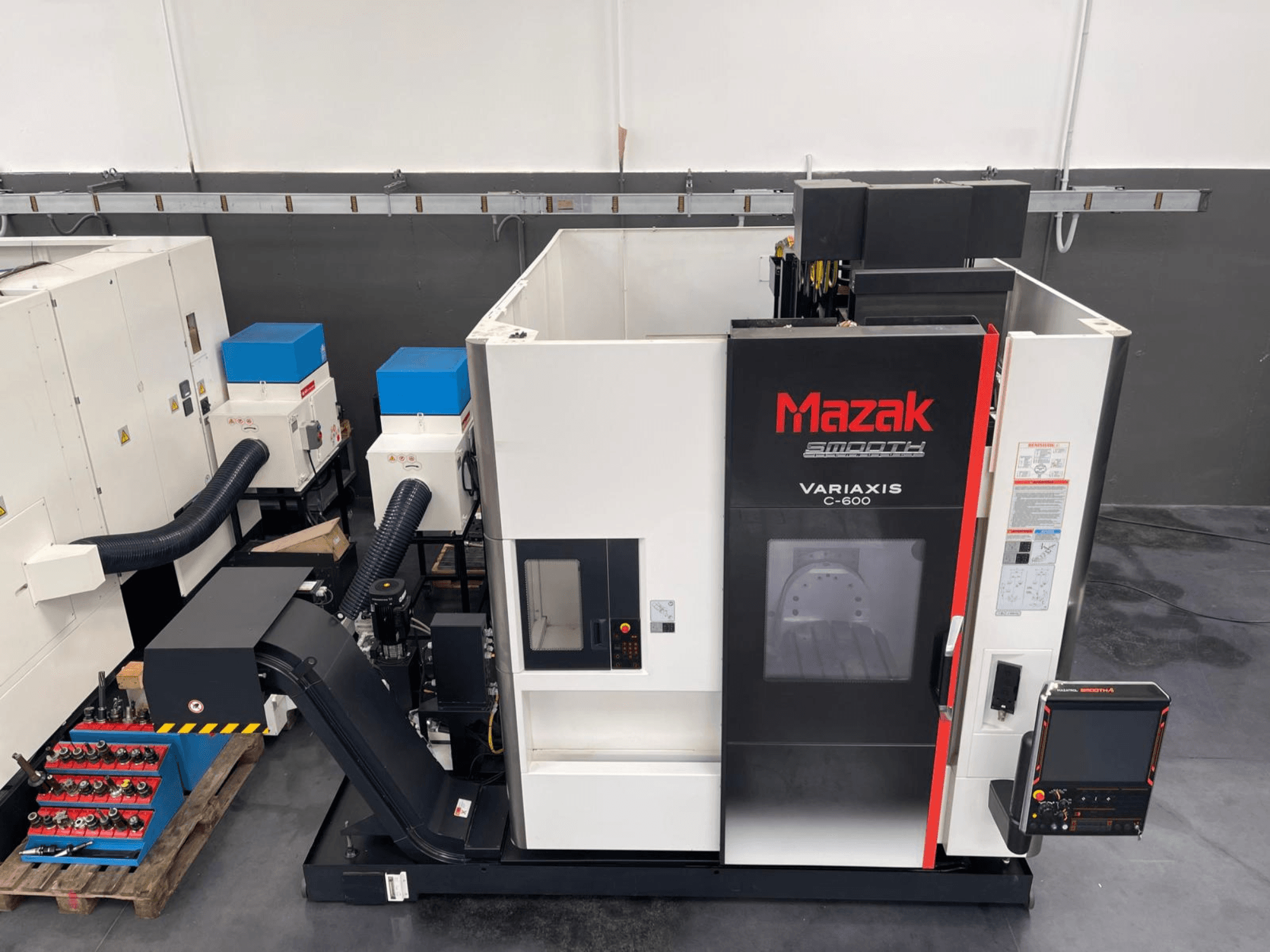 Centro de maquinação vertical Mazak VARIAXIS C 600, vista frontal mostrando o painel de controlo e o armazenamento de ferramentas.