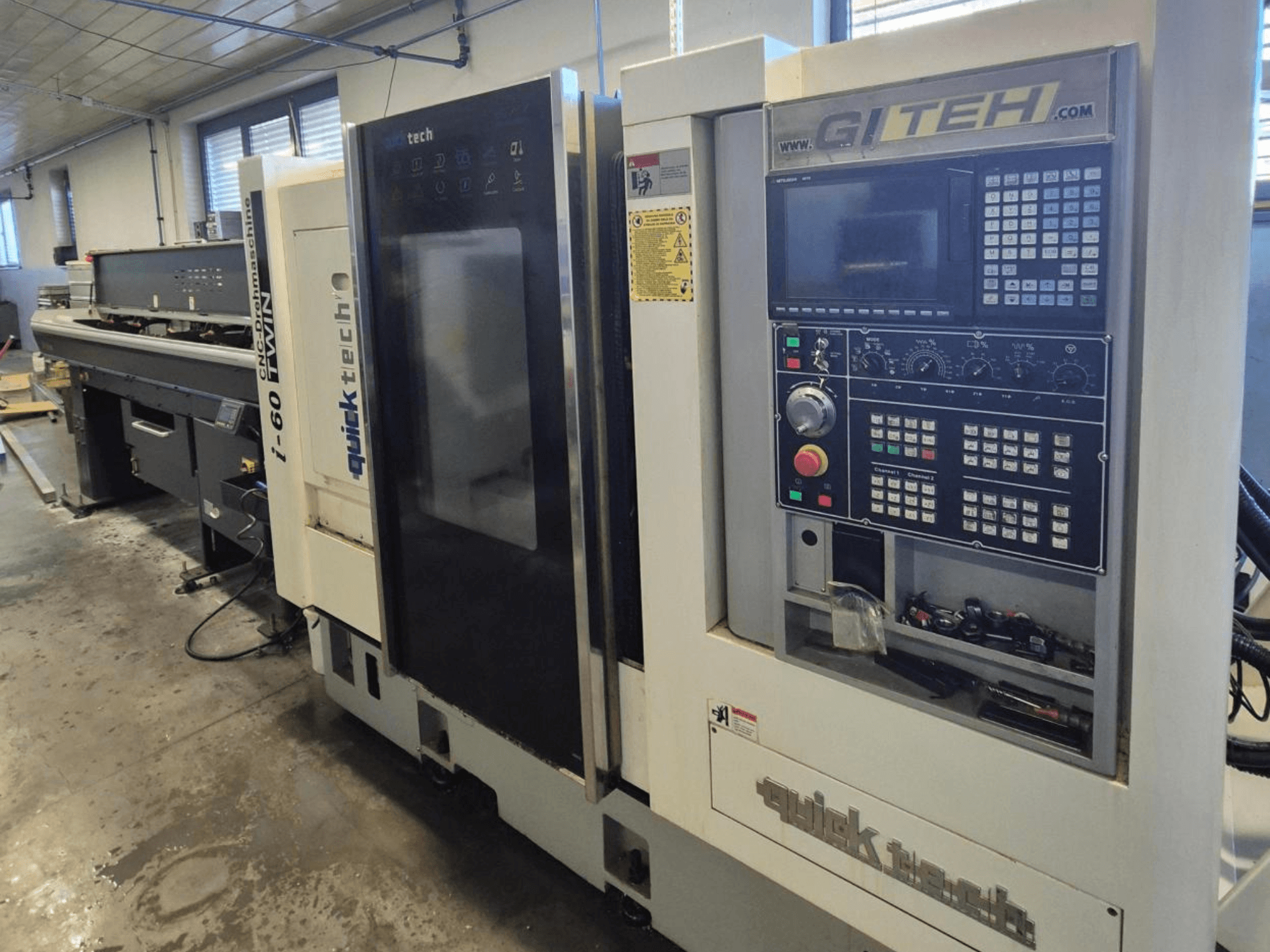 Máquina CNC dupla Quick Tech i-60, vista frontal, com painel de controlo GITEH e botões operacionais, numa oficina.