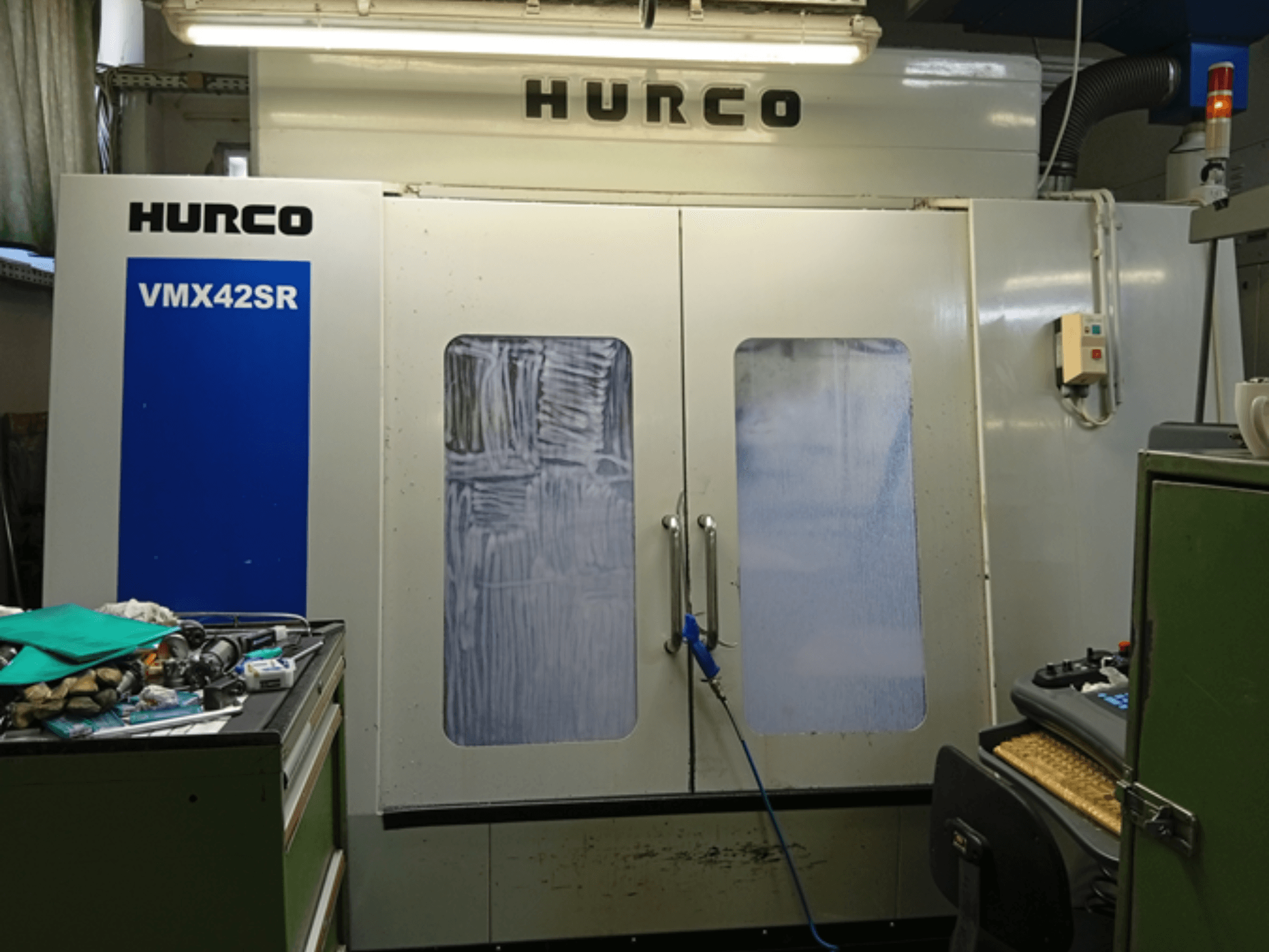 Centro de maquinação vertical Hurco VMX 42SR em vista frontal, com painel azul, interface de controlo e espaço de trabalho limpo.