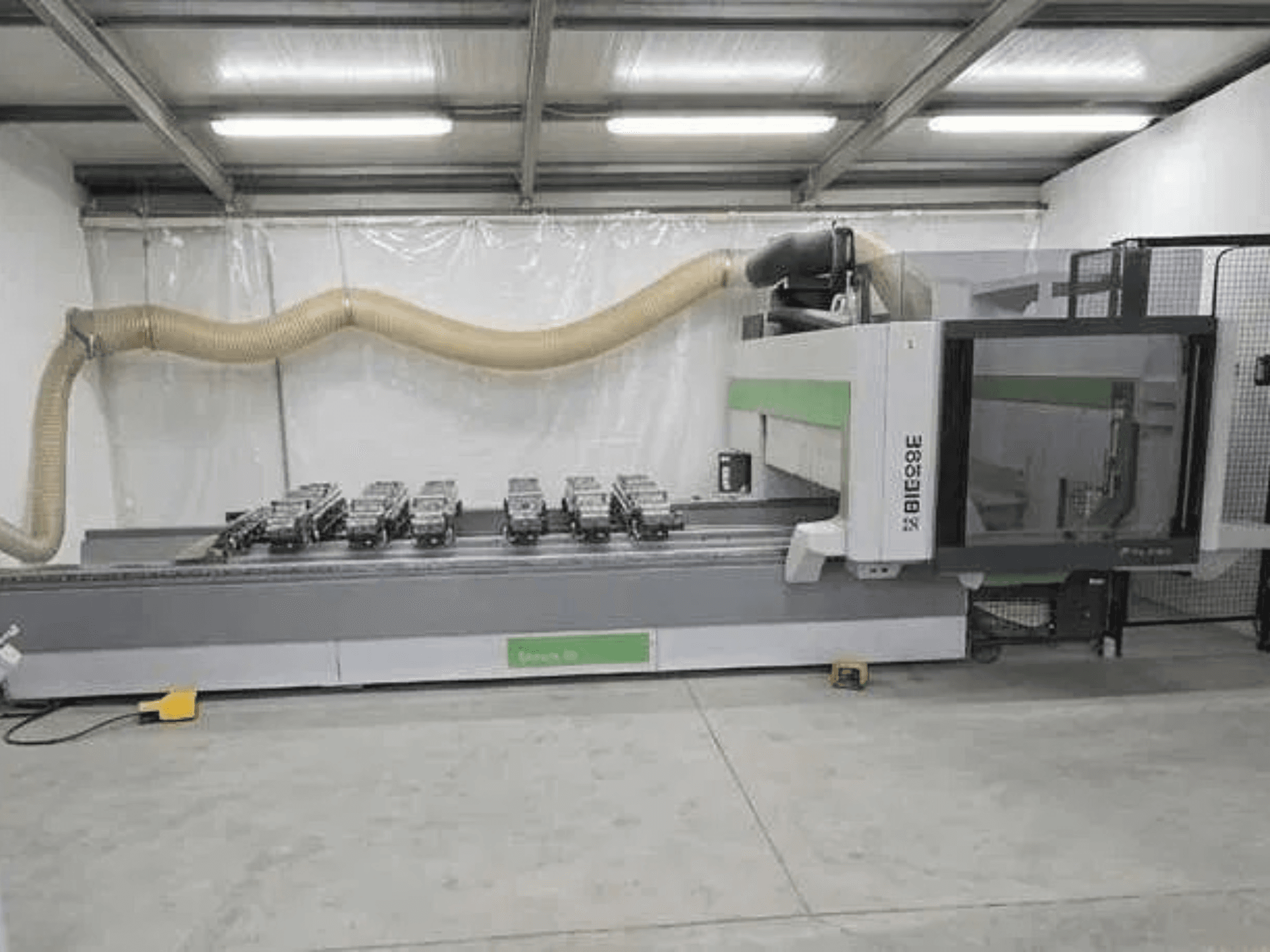 Centro de processamento CNC BIESSE Rover K1232, visto de lado, com ventosas de vácuo e sistema de extração de poeira visíveis.