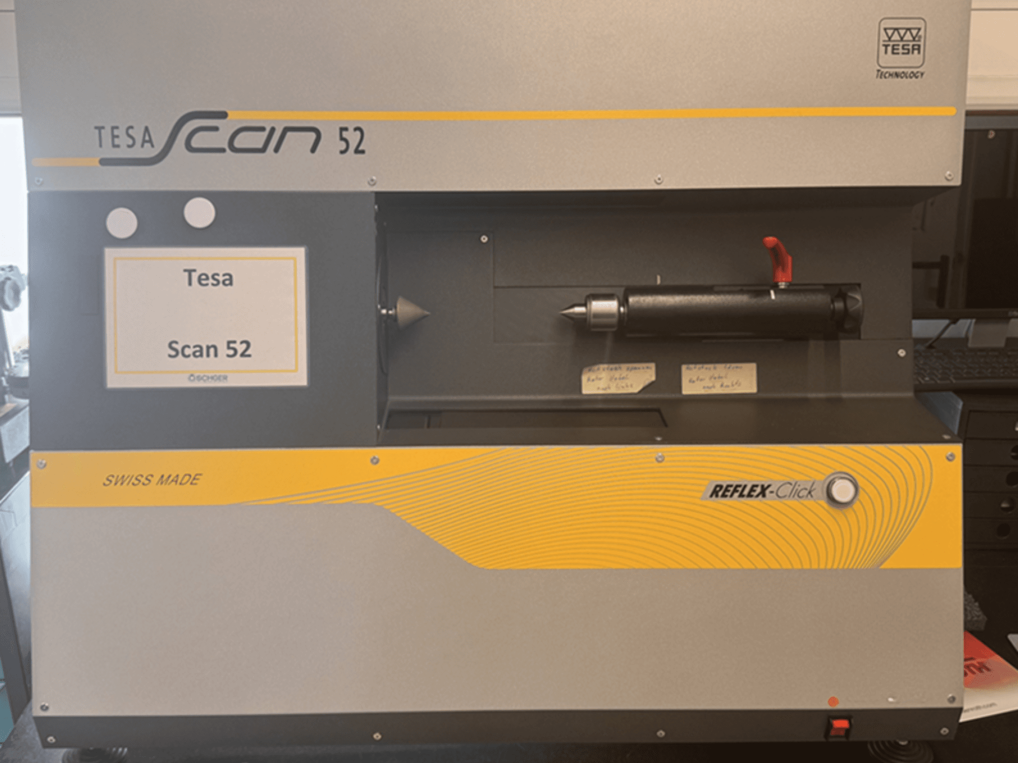 Vista frontal da máquina de medição ótica TESA Scan 52, com os botões de comando e a etiqueta «SWISS MADE» visíveis.