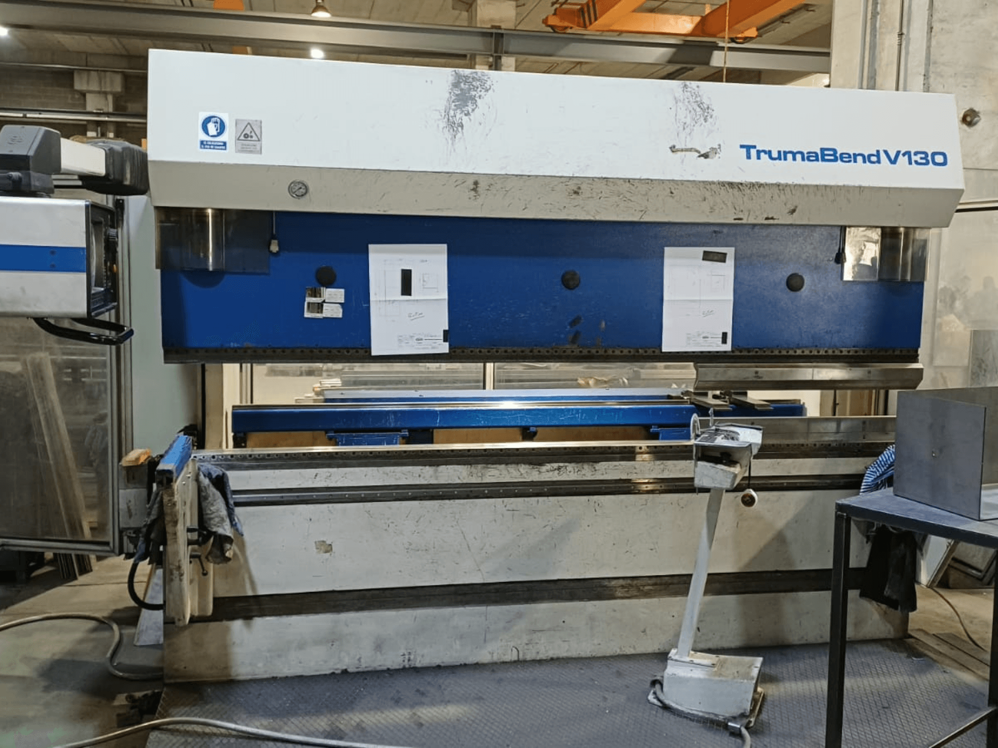 Prensa-dobra TRUMPF Trumatic Trumabend V130 vista de frente, mostrando o painel de controlo, a superfície de trabalho e as ferramentas ajustáveis.