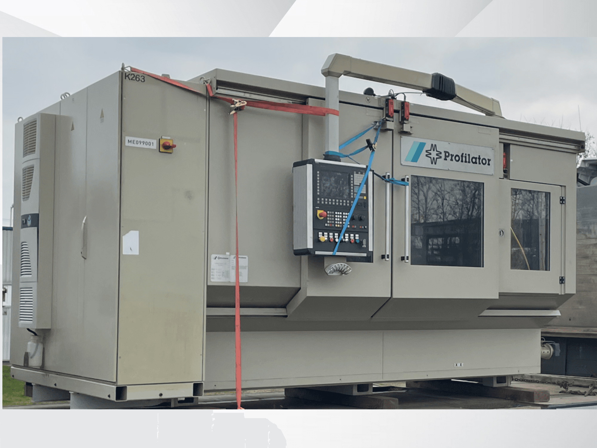 Máquina perfiladora em vista lateral, com painel de controlo, etiquetas de segurança e cintas de proteção, sobre uma plataforma de madeira.