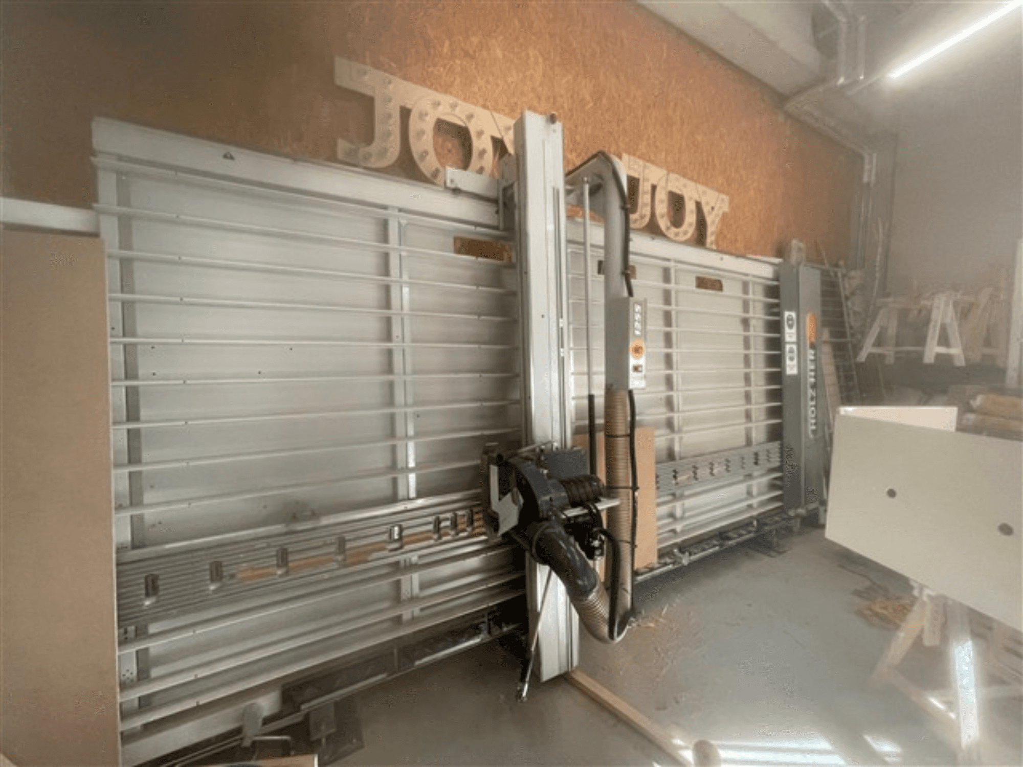 Serra de painel horizontal, marca Holz-Her, vista lateral, mostra a lâmina de serra, a extração de poeiras e o espaço de armazenamento.