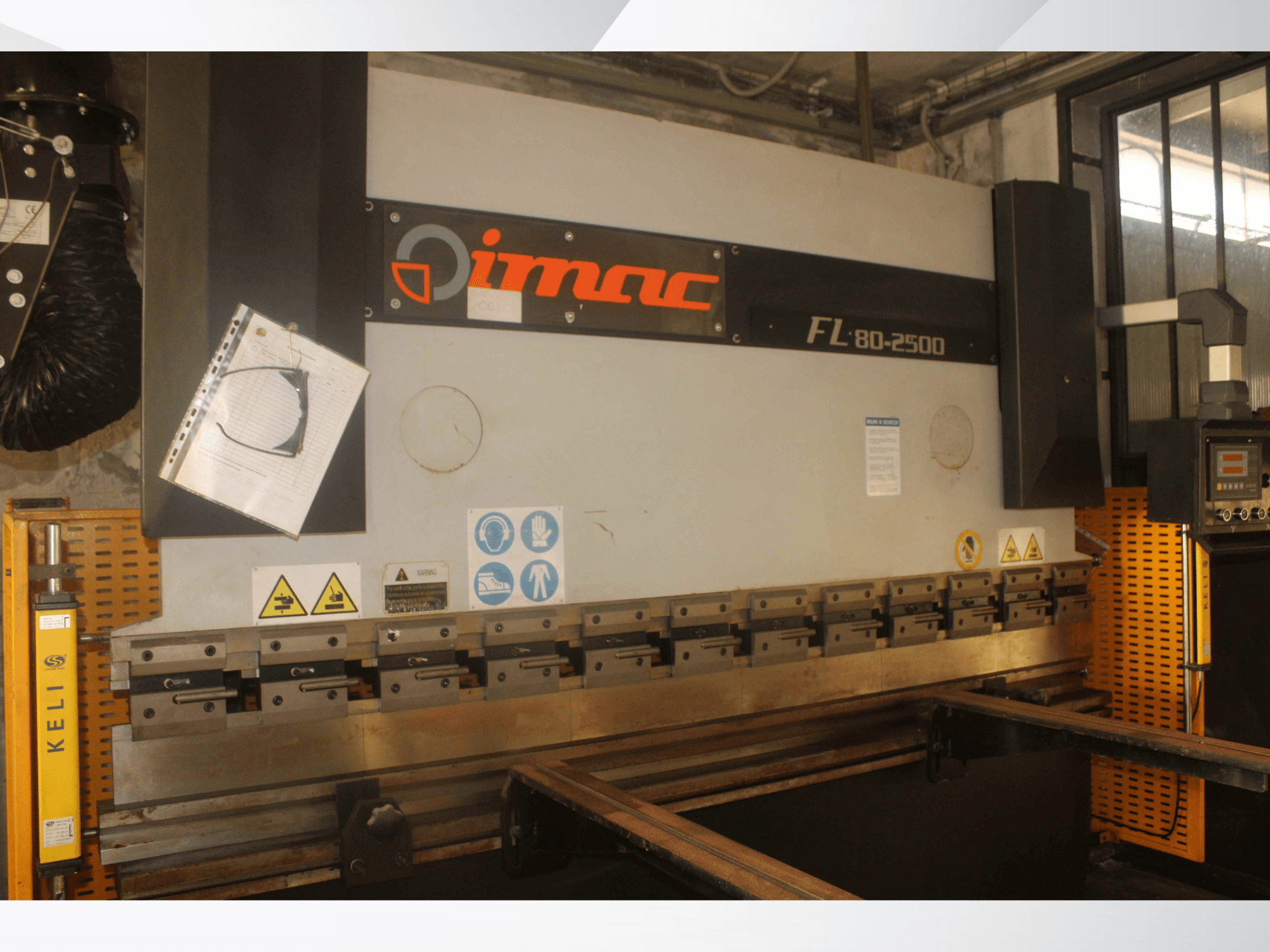 Máquina de dobragem IMAC FL 80-2500, vista frontal, com painel de controlo, avisos de segurança e componentes de ferramentas metálicas.