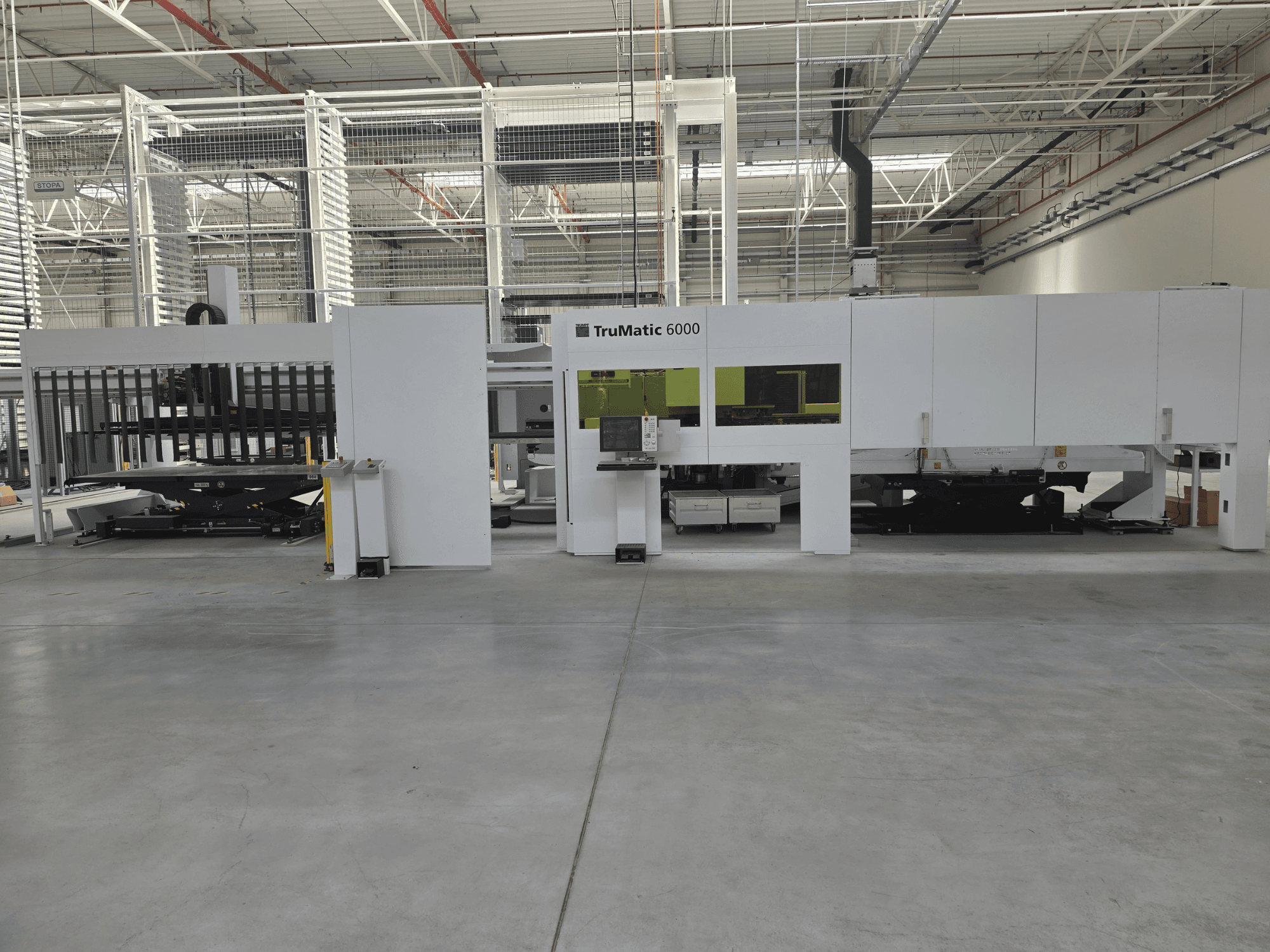 Sistema automatizado de produção de chapa metálica TRUMPF TruMatic 6000, vista frontal, com painel de controlo e área de carregamento.