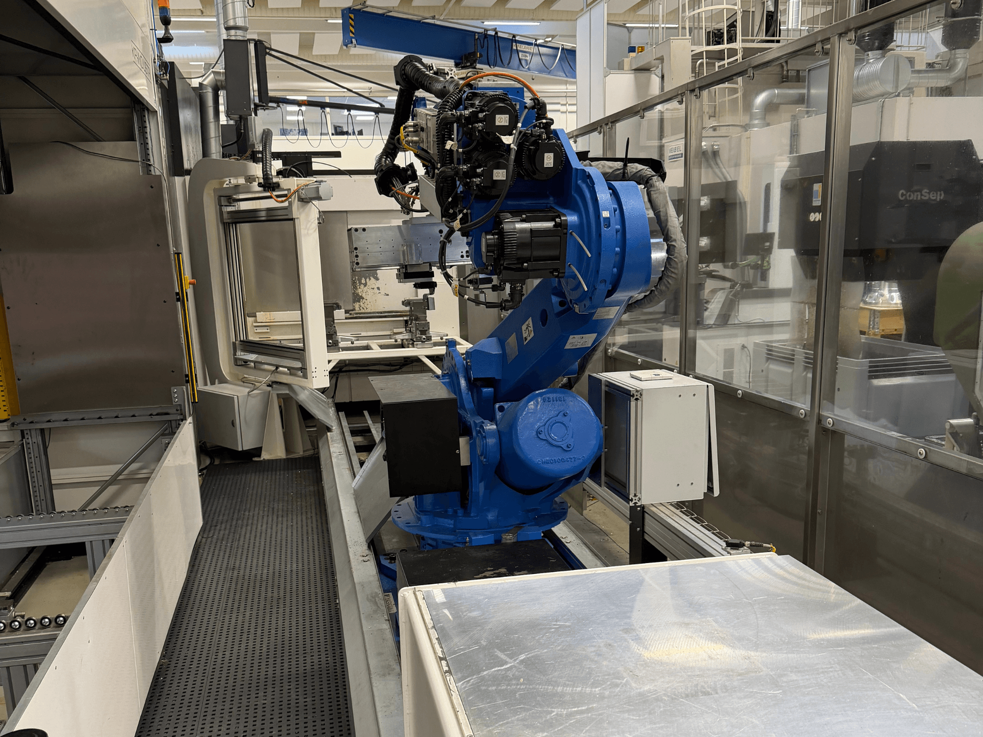 Braço robótico Yaskawa Motoman ES165D sobre carril, vista lateral mostrando a configuração da automação em ambiente industrial.