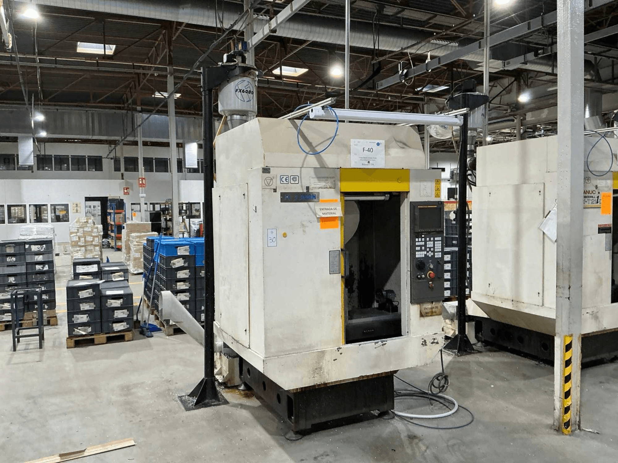 FANUC ROBODRILL α-T21iD, vista frontal do centro de maquinação vertical num ambiente industrial, com detalhes do painel de controlo visíveis.