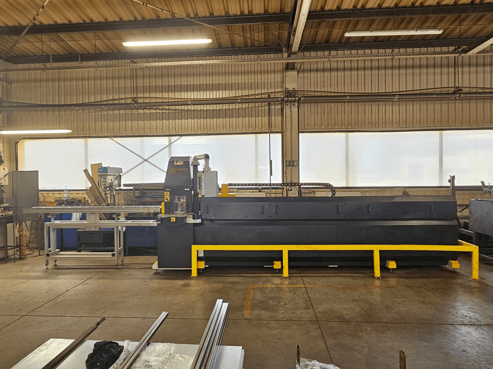 Máquina de perfuração CNC PARS HMP SIRIUS PLUS-3000/3-L1, vista frontal num ambiente industrial com superfícies metálicas e ferramentas.
