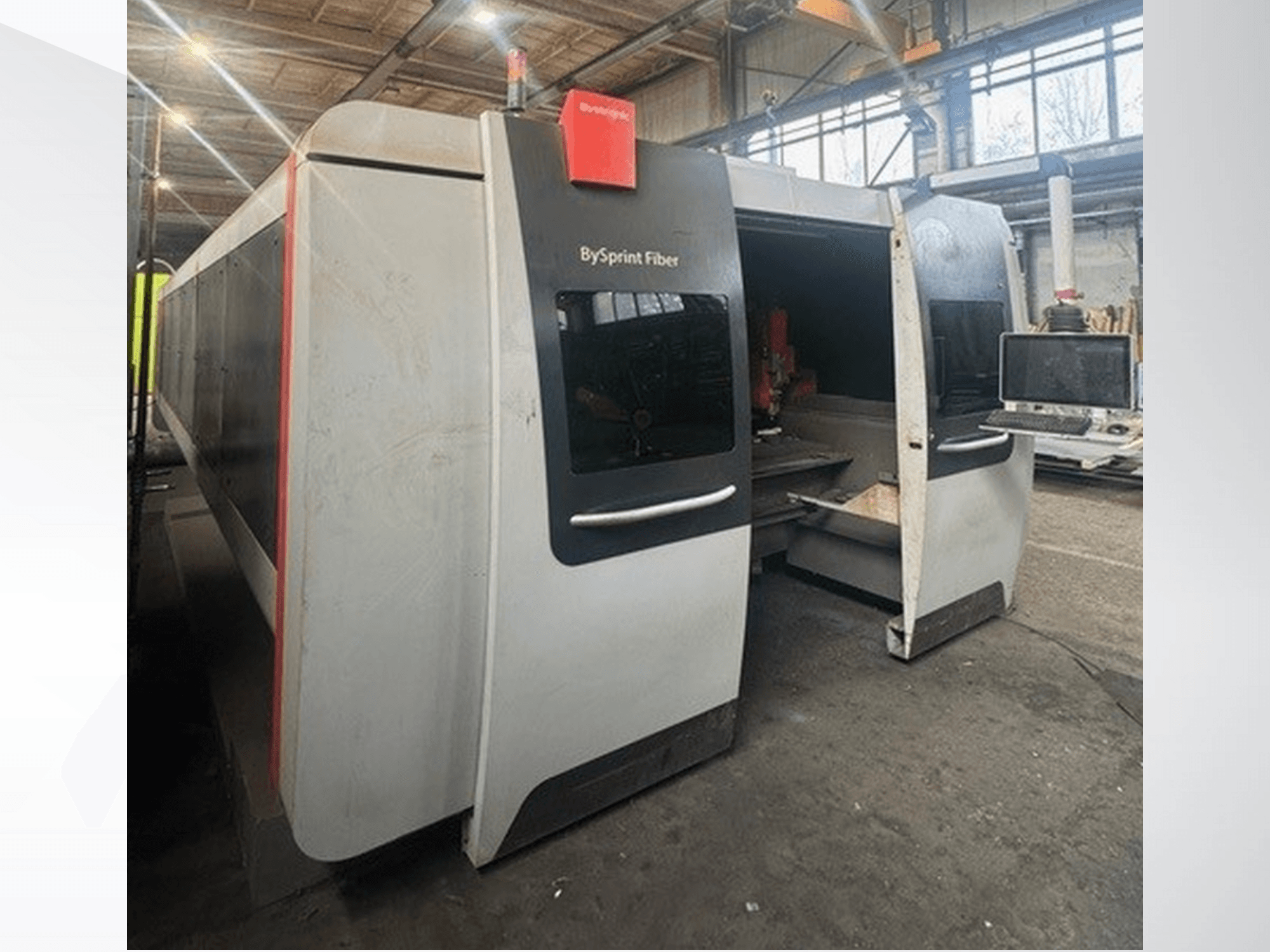 Máquina BySprint Fiber da Brünswick, vista frontal mostrando aberturas duplas, painel de controlo com ecrã tátil e espaço de trabalho industrial no interior.