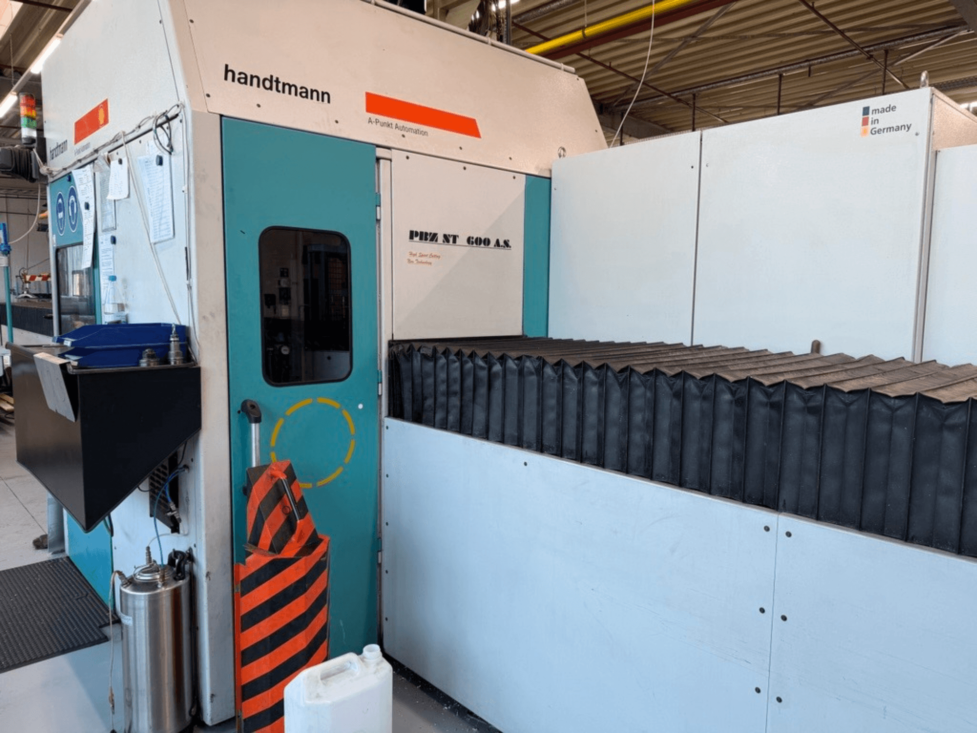 Vista frontal da fresadora de pórtico PBZ NT 600 AS da Handtmann, com superfície de trabalho escura e barreiras de segurança.