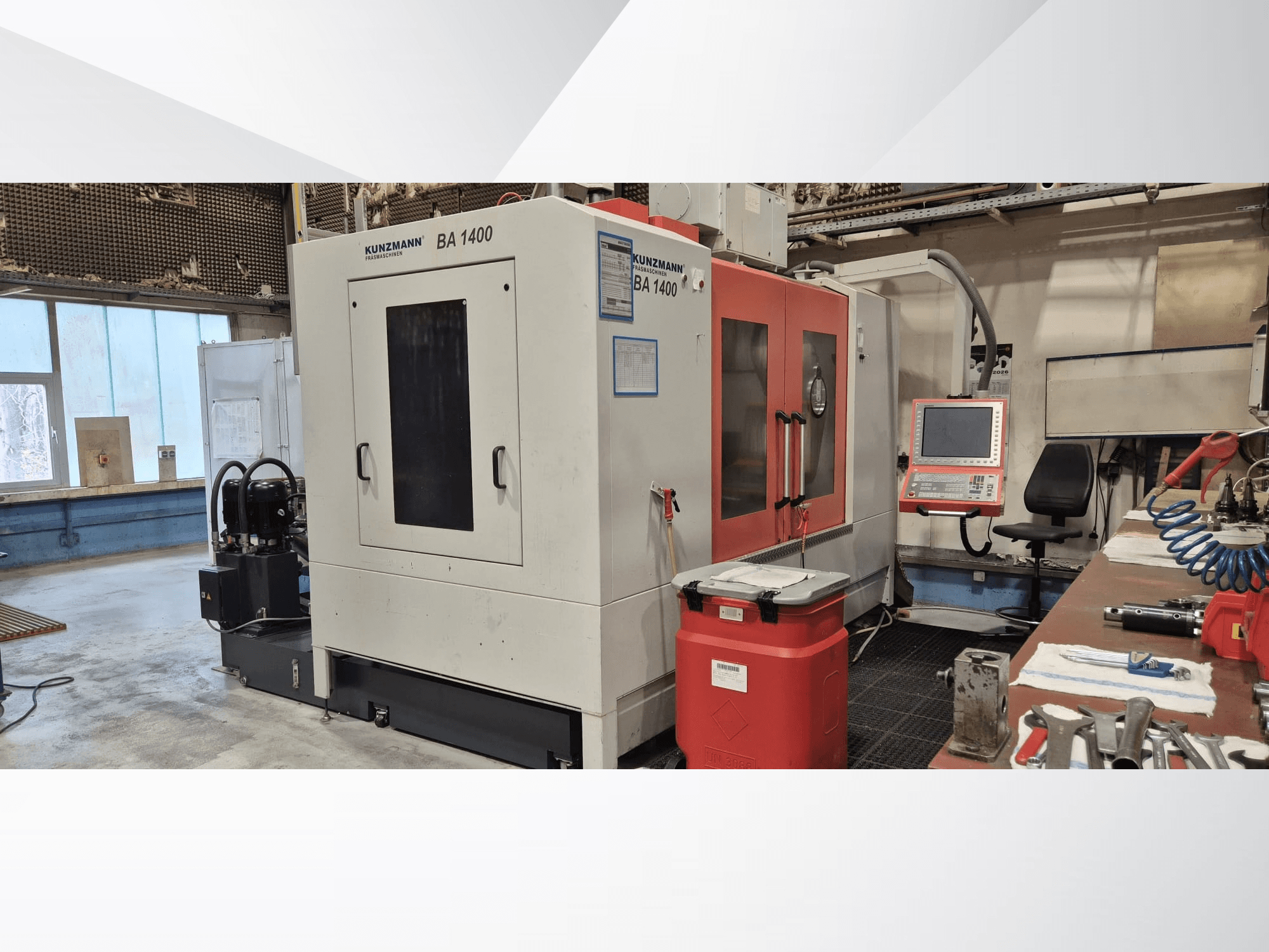Centro de maquinagem vertical KUNZMANN BA1400 numa oficina, vista lateral que mostra o painel de controlo e as ferramentas à sua volta.